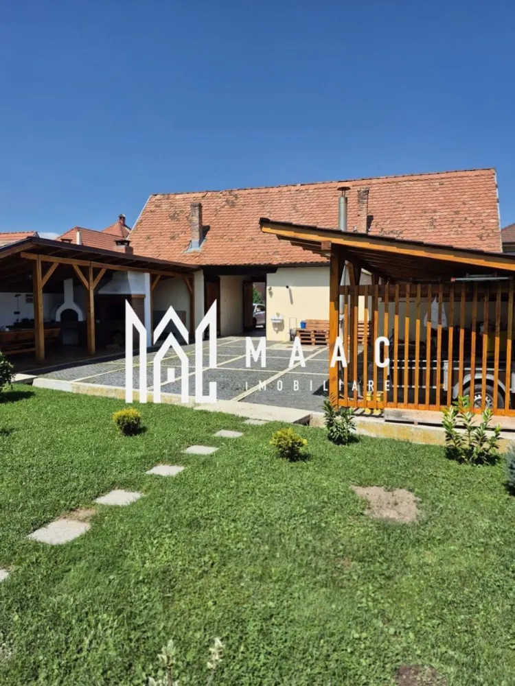 Casă spațioasă cu 5 camere I 1.000 mp teren I Rășinari I Sibiu - Casă spațioasă de vânzare în Rășinari, jud. Sibiu

O proprietate ideală pentru cei care caută liniștea naturii, dar vor să rămână aproape de oraș.

Caracteristici principale:
Suprafață utilă: 200 mp
Teren generos: 1.000 mp, cu curte mare și grădină amenajată
Compartimentare eficientă: 5 camere, living generos, bucătărie închisă, 2 băi
Foișor, zonă de relaxare cu grătar – perfectă pentru momente petrecute în familie sau cu prietenii
Gazon întreținut, spațiu verde ideal pentru joacă, relaxare sau grădinărit

Utilități și dotări:
Toate utilitățile: apă, canalizare, gaz, electricitate
Încălzire prin centrală pe gaz și lemne – alternativă practică și economică
Liberă de orice sarcini – actele sunt pregătite pentru vânzare

Localizare:
Casa este situată într-o zonă liniștită din Rășinari, la doar câțiva kilometri de Sibiu – un cadru natural deosebit, cu acces facil către oraș.
Potrivită ca locuință de familie, casă de vacanță sau investiție turistică.

Pentru detalii suplimentare, consultanță sau programarea unei vizionări, te rugăm să ne contactezi si sa specifici CP2722226.