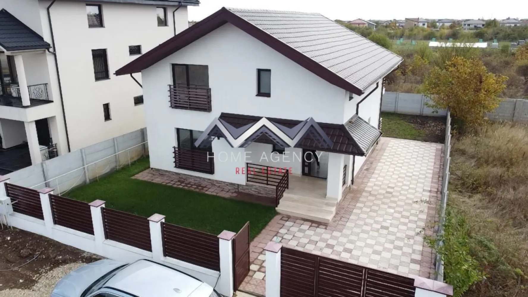 Casă individuală de vânzare Balotești - Vă propunem, spre vânzare, o casă individuală P+1, amplasată în Balotești, într-o zonă liniștită și aerisită, aflată în plină dezvoltare, cu acces facil către DN1, Aeroportul Otopeni și complexul Therme. Proprietatea se remarcă prin compartimentarea practică, camerele spațioase și luminoase, precum și prin calitatea construcției, concepută pentru confortul unei familii moderne.

Construită integral din cărămidă, cu izolație exterioară și interioară și acoperiș din tablă, casa dispune de o suprafață utilă de 114 mp și o amprentă la sol de 90 mp, pe un teren de 400 mp. Curtea liberă de aproximativ 320 mp este complet împrejmuită, oferind intimitate și un cadru plăcut pentru relaxare.

La parter găsim un living generos, cu ferestre mari ce permit luminii naturale să pătrundă pe tot parcursul zilei și cu acces direct spre grădină. Bucătăria este închisă cu pereți de sticlă, oferind un efect elegant și modern, separând zona de gătit de spațiul de zi fără a diminua luminozitatea. Tot aici regăsim un dormitor spațios, potrivit pentru oaspeți, birou sau cameră de hobby, și o baie mare, cu duș tip walk-in, amenajată modern.

Etajul este destinat odihnei, oferind intimitate și confort. Dormitorul matrimonial se remarcă prin dimensiunile generoase, accesul spre balconul propriu, o zonă de dressing și o baie proprie dotată cu cadă. Celelalte două dormitoare sunt luminoase și bine proporționate, deservite de o baie comună, dotată cu duș walk-in. Din holul etajului se face accesul către pod, un spațiu extrem util pentru depozitare suplimentară.

Finisajele sunt moderne și de bună calitate: ferestre PVC cu geam tripan pentru izolare termică și fonică, parchet laminat premium, pereți finisați cu vopsea lavabilă, faianță și gresie în tonuri neutre, ușă metalică la intrare și sistem de încălzire cu centrală proprie și calorifere. Casa se vinde nemobilată, oferind libertatea noilor proprietari de a o amenaja după propriul stil.

Curtea este îngrijită, beneficiază de pavaj pe aleile de acces și zona de parcare, gazon amenajat și un foișor cu magazie, util atât pentru depozitare, cât și pentru activități în aer liber. Spațiul exterior este ușor de întreținut și oferă echilibrul între relaxare și utilitate, fiind potrivit pentru o familie.

Proprietatea se distinge prin camerele sale ample și luminoase, compartimentarea echilibrată și liniștea zonei, fiind o alegere potrivită pentru cei care își doresc o locuință nouă, confortabilă și bine construită, la doar câteva minute de Nordul Capitalei.

Contactează-ne pentru mai multe detalii și pentru programarea unei vizionări.