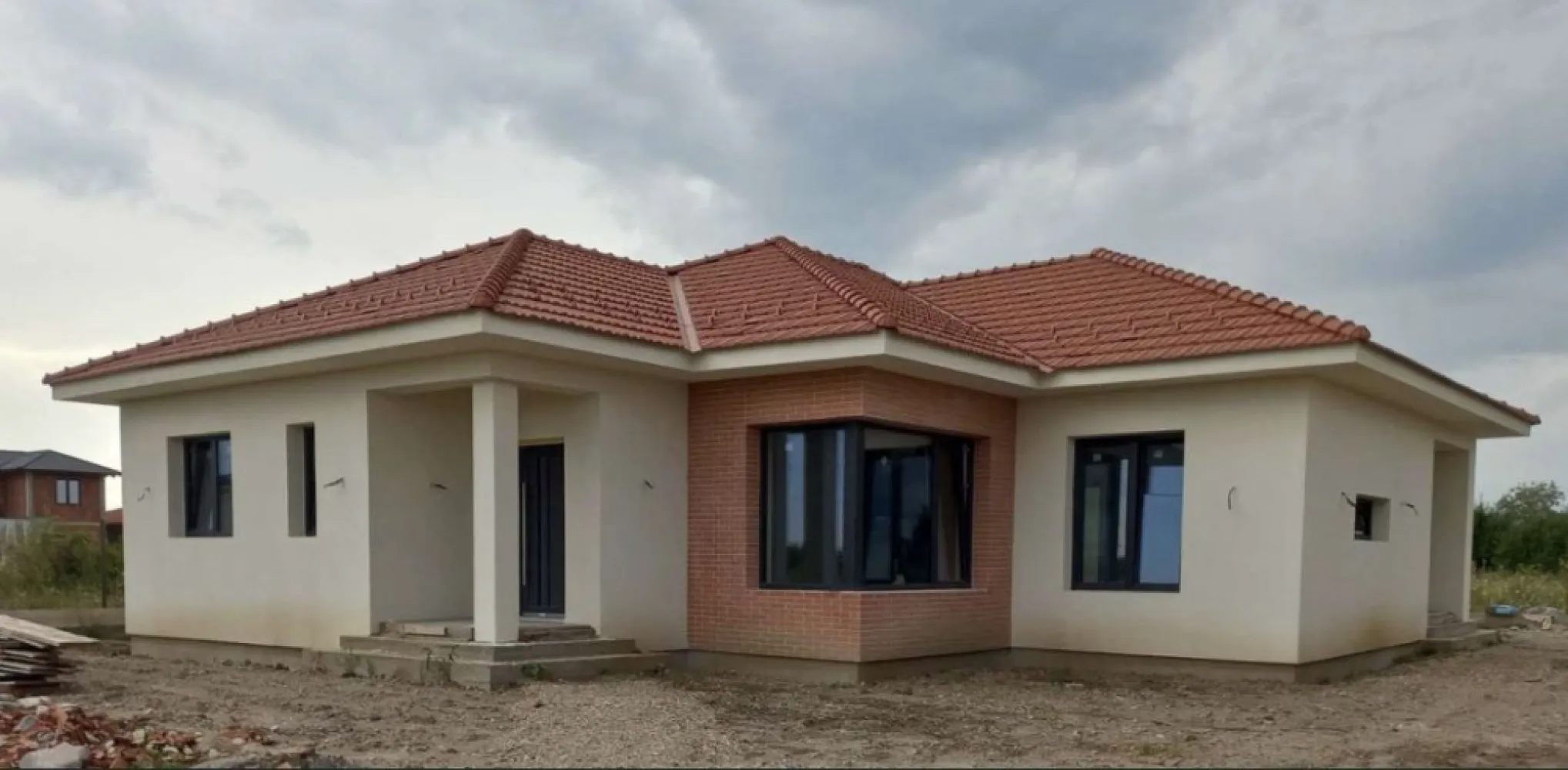 Vand casa Paulesti - Locatie: loc. Paulesti, str. Andrei Muresanu, nr. 12, jud. Satu Mare (proprietate usor accesibila de la strada Principala, fie prin str. Ghioceilor/str. Randunelelor/str. Nicolae Balcescu). Suprafata teren = 600mp (22.10m x 27.15m) Suprafata construita la sol (amprenta) = 175mp Suprafata utila = 142mp Compartimentare: intrare acoperita, vestibul, living, dining, bucatarie, hol, doua bai, trei dormitoare (din care unul matrimonial, cu dressing si baie proprie), spalatorie, camera tehnica si terasa acoperita. Detalii constructive: - Izolatie - Termosistem la fatada este realizata cu vata minerala bazaltica pentru fatada, in grosime de 20cm Rockwool Frontrock Casa (grosime maxima ce se gaseste de vanzare si probabil cea mai buna calitate); - Tamplarie PVC Salamander 92mm (probabil, cea mai performanta la ora actuala) cu 6 camere de izolare si geam termoizolant triplu. Aceasta a fost achizitionata si montata cu cei de la ASO din Baia Mare. Pentru ferestre se poate analiza in detaliu fereastra-aso.ro/exclusiv/, iar pentru usa din terasa fereastra-aso.ro/usi-culisante-cu-ridicare/. - Planseu din beton armat - La acoperis este montata astereala din scandura pe toata suprafata, iar peste aceasta este montata folie anticondens, sipci, contrasipci si invelitoare din tigla ceramica Tondach. - Inaltimea libera intre pardosela si tavan = 2.85m STANDARDUL nZEB Foarte important: casa este proiectata sa se incadreze in Standardul nZEB (Nearly Zero Energy Building), varianta V3 - consum de energie anual mai mic, cel mult egal cu 110 kwh/mp/an – energie primara bruta. STADIU LA PREDARE: La exterior: finalizat. La interior: peretii si tavanul gata pregatiti a fi dati cu lavabila (au fost aplicate tencuiala manuala, si doua staraturi de glet), instalatii sanitare si electrice finalizate, incalzirea in pardoseala finalizata si sapa turnata peste izolatiea la placa pardosela din polistiren de 10cm grosime gata pregatita pentru montaj pardoseli. Curtea nivelata si imprejmuita pe trei laturi. Vor fi puse la dispozitie utilitatile apa, canal - fosa septica si electricitate. Strada Andrei Muresanu este recent asfaltata. Toate lucrarile au fost executate doar cu personal calificat (maistru in constructii), urmarite de inginer constructor si supervizate de diriginte de santier atestat. In momentul vanzarii se va preda cartea tehnica a constructiei cu totalitatea istoricului constructiei, procese verbale de lucrari ascunse, condica de betoane, certificate de conformitate si calitate a tuturor materialelor puse in opera si imagini reale din timpul executiei lucrarilor.