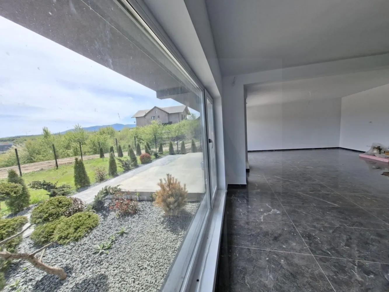 Casă moderna premium 195 mp utili cu garaj și teren 815 mp în Selimbar - Agenția imobiliară Azura Estate vă propune spre vânzare o casă modernă, premium, eficient compartimentată, ideală pentru o familie, situată într-o zonă liniștită și accesibilă din Selimbar. Proprietatea dispune de 4 camere, dintre care 3 dormitoare spațioase 17,2 mp, 18,8 mp și 18,9 mp, concepute pentru a oferi confort, intimitate și lumină naturală din plin.

Zona de zi este generoasă și primitoare, fiind organizată eficient în sistem open space, cu o cameră de zi de 30,5 mp și zonă de dining de 17 mp, completate de o bucătărie de 10,2 mp, rezultând un spațiu aerisit.

Proprietatea se deschide către un cadru aerisit, cu o perspectivă largă și neobstrucționată, oferind liniște si intimitate, curtea este atent amenajată, cu alei pavate elegant, zone decorative cu piatră naturală și vegetație ornamentală matură care conturează armonios spațiul verde.
Zona de gazon generos oferă multiple posibilități de amenajare – fie că îți dorești o grădină spectaculoasă, un loc de relaxare sau un spațiu dedicat familiei. Vegetația perimetrală asigură un echilibru perfect între estetic și intimitate.

Casa impresionează prin arhitectura modernă, cu linii curate, terasă spațioasă și balcon cu sticlă securizată, ideale pentru momentele de relaxare în aer liber. Deschiderea către natură și poziționarea într-o zonă aerisită completează perfect imaginea unei locuințe premium.

• Suprafață utilă demisol: 80,4 mp
• Suprafață utilă parter: 115,2 mp
• Suprafață construită desfășurată: 153 mp
• Terasă neacoperită: 19,4 mp
• Balcon: 15,9 mp
• Podest acces: 6,1 mp

Parter
• Cameră de zi: 30,5 mp
• Loc de luat masa: 17,0 mp
• Bucătărie: 10,2 mp
• Cămară / debara: 4,7 mp
• Cameră tehnică + spălătorie: 9,7 mp
• Baie: 4,8 mp
• Acces către terasă: 19,4 mp
Etaj
• Dormitor matrimonial + dressing: 18,9 mp
• Dormitor + dressing: 18,8 mp
• Dormitor: 17,2 mp
• Dressing: 5,0 mp
• Baie: 6,3 mp
• Holuri: 5,5 mp + 7,0 mp
• Garaj: 36,5 mp
• Balcon: 15,9 mp

Pretul acestei case este de 270000 Euro