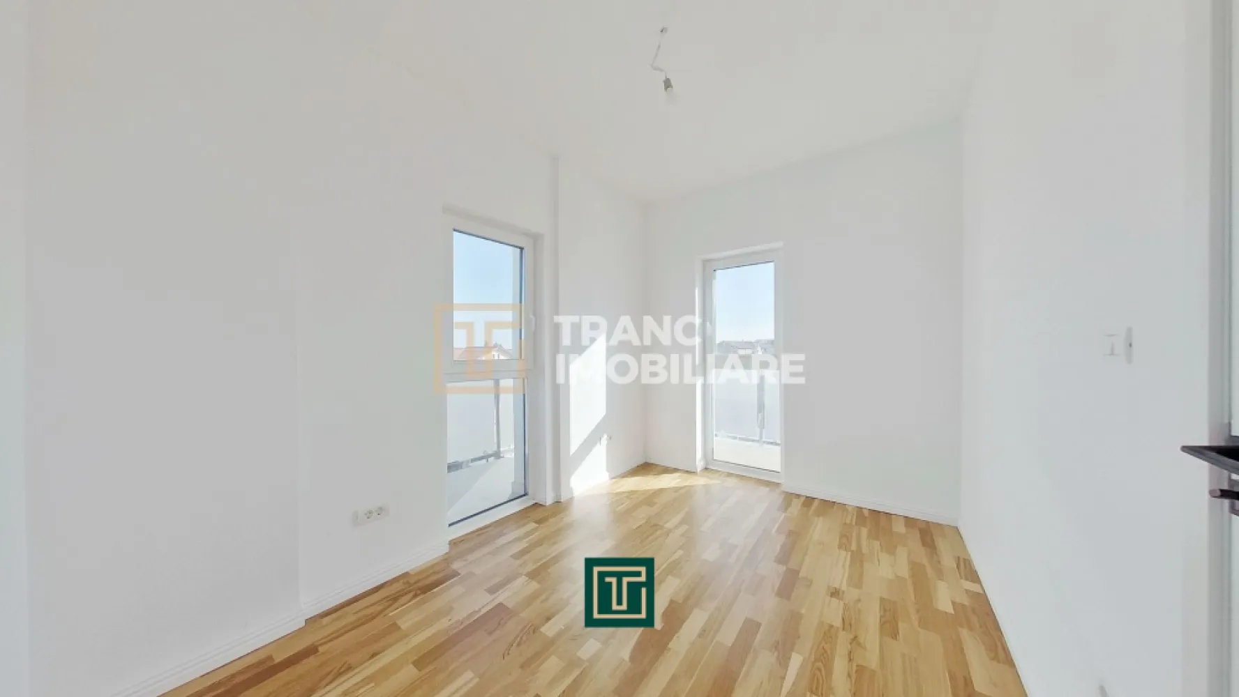Apartament modern cu 3 camere in bloc nou in Micalaca zona Miorita - In continuare ne face o deosebită plăcere să îți prezentăm un apartament cu 3 camere într-un bloc nou și modern, cu lift, construit în 2023, poziționat pe Calea Radnei, în Micalaca, zona Miorița, vis-a-vis de Rompetrol, într-o zonă unde blocurile noi apar rar, iar proprietățile moderne, bine gândite, se vând repede. Apartamentul are 57 mp utili și un balcon generos de 14 mp, iar compartimentarea este exact genul acela care îți face viața mai ușoară zi de zi, fără spații irosite și fără compromisuri. În plus, blocul este dotat cu lift, un detaliu care contează enorm în confortul zilnic, indiferent de vârstă sau stilul tău de viață.

În interior te întâmpină o sufragerie luminoasă în open space cu bucătăria, un spațiu aerisit, modern, susținut de geamuri vitrate mari care lasă lumina naturală să intre exact cât trebuie. Holul de intrare și zona open-space sunt puse în valoare de un tavan decorat cu scafe și proiecții LED, pe care le poți seta în culorile pe care le dorești, astfel încât atmosfera să fie mereu adaptată stării tale: cald și relaxant seara, elegant când ai musafiri, discret când vrei liniște.

Confortul este completat de încălzirea prin pardoseală, asigurată de o centrală termică pe gaz, astfel încât ai o temperatură plăcută, uniformă, și control total asupra consumului și ambientului, exact cum își dorește cineva care vrea un apartament modern, făcut pentru viața reală.

Zona de noapte este clară și practică, ai un dormitor matrimonial pentru intimitate și odihnă și un dormitor pentru copil, perfect și ca dormitor, și ca spațiu de studiu sau birou, în funcție de nevoile tale. Parchetul este nou, premium, triplustratificat, iar asta se simte imediat, nu doar ca aspect, ci și ca senzație de confort.

Unul dintre punctele forte reale ale apartamentului este balconul, Cu 14 mp, pe două părți, cu acces atât din sufragerie, cât și din dormitorul matrimonial. Este acel tip de detaliu care schimbă complet felul în care folosești casa, pentru că ai un spațiu exterior real, conectat natural cu zona de zi și cu intimitatea dormitorului. Balconul este modern, cu rame de metal și sticlă, într-un design minimalist, plăcut și elegant, genul acela care arată bine și peste ani.

Baia este luminoasă, are duș și este completată de o oglindă luminată, un detaliu mic, dar care ridică imediat senzația de „nou” și de spațiu îngrijit, bine finisat.
Dacă îți dorești un apartament nou, modern, cu lumină naturală, încălzire în pardoseală, finisaje care se simt premium, un balcon mare cu design minimalist și o compartimentare practică pentru viața de zi cu zi, atunci merită să-l vezi pe viu. Pentru detalii și programarea unei vizionări, scrie-mi sau sună-mă.