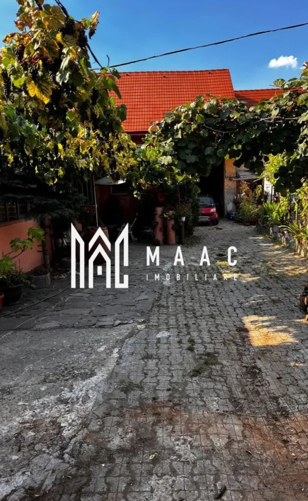 Casa individuala | Teren 510 mp | Cisnadie - MAAC Imobiliare va propune spre vanzare o casa individuala,situata in zona centrala a orasului Cisnadie.

Detalii generale:

Suprafață teren: 510 mp
Suprafata utila: 176 mp
Garaj: 60 mp
Curte: 128 mp
Grădină de 147 mp și fântână proprie.

Aceasta casa este ideală atat pentru locuință cat și pentru afacere (spațiu comercial, after-school, loc de joacă).
Dispune de incalzire in pardoseala, avand centrala proprie.
Acoperisul a fost recent renovat cu țiglă nouă.

Locuința 1:
Configurație: Pivniță + Parter + Mansardă.
Pivniță: 16,86 mp.
Parter: 82,42 mp (Hol, cămară, debara, bucătărie, baie, living – parțial amenajate).
Etaj/Mansardă: 92,76 mp neamenajați (plan existent pentru 3 dormitoare, fiecare cu dressing și o baie).
Utilități: Branșamente separate (gaz, apă, curent).

Locuința 2:
Configurație: Parter.
2 dormitoare: 16,7 mp fiecare.
Living open-space cu bucătărie: 23 mp.
Cămară: 7 mp.
Baie: 8 mp.
Birou: cameră separată.
Verandă.
Spații anexe:
Garaj: 59 mp – clădire separată.
Curte: 128 mp – împărțită cu o altă persoană.
Grădină: 147 mp – ideală pentru relaxare sau amenajări personalizate.

Pentru mai multe detalii sau pentru a programa o vizionare va rugam sepcificati telefonic ID: CP2247889