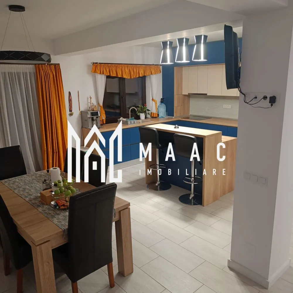 Casa 4 camere | Curte proprie | Panouri solare | Sura Mica - MAAC Imobiliare vă propune spre vânzare un duplex situat în Șura Mică, într-o zonă rezidențială apreciată pentru liniște și acces facil către oraș. Proprietatea a fost construită în anul 2021 și este amplasată pe un teren de 200 mp, având o suprafață utilă totală de 115 mp, distribuită pe două niveluri, câte 57,5 mp pe fiecare etaj.

Locuința este eficient compartimentată, cu parter open space și zonă de noapte bine delimitată la etaj, oferind confort și funcționalitate pentru o familie.

Compartimentare:
-Parter: living generos cu șemineu, spațiu de servit masa (dining), bucătărie cu insulă complet utilată, cămară, baie cu cabină de duș și geam de aerisire
-Etaj: 2 dormitoare fiecare cu balcon propriu, 1 dormitor amenajat ca office space, baie cu geam de aerisire și cadă, debara

Exteriorul este amenajat pentru relaxare și activități în aer liber, incluzând terasă mobilată la parter, spațiu de parcare pentru 2 mașini, grătar generos din fier cu spațiu de lucru, jacuzzi , wellnese spa și pivniță.

Casa este racordată la toate utilitățile și se vinde complet mobilată și utilată, incluzând electrocasnice precum aragaz, aspirator, cafetieră, cuptor cu microunde, fier de călcat, frigider, hotă, mașină de spălat rufe, mașină de spălat vase, robot de bucătărie, sandwich-maker, toaster și TV. Proprietatea beneficiază de panouri solare de 3 kW montate în 2024.

Pentru mai multe detalii precizați telefonic că ați văzut anunțul cu CP2103454.