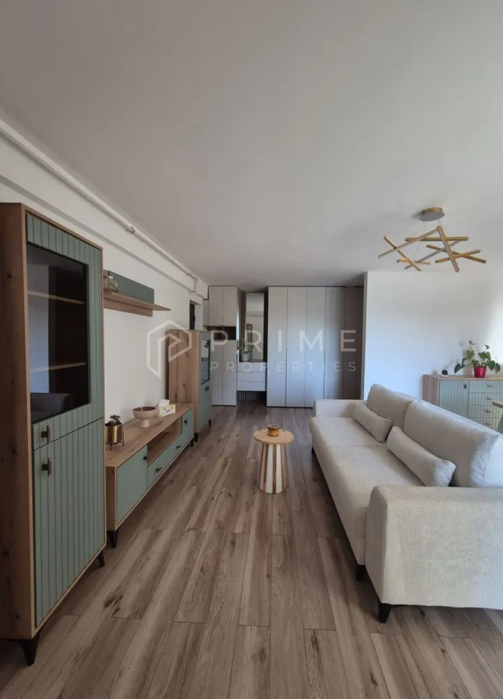 Apartament Premium 2 Camere | Ama Residence Unirii | - Echipa noastră vă invită să descoperiți un apartament nou, situat într-un imobil proaspăt finalizat pe strada Prof. Dr. Vasile Săbădeanu, în cartierul Unirii. Această proprietate premium, aflată la prima închiriere, îmbină perfect eleganța designului modern cu eficiența unui spațiu configurat pentru relaxare.

Design & Atmosferă:
Interiorul impresionează prin culori calde și texturi naturale, fiind creat special pentru a oferi confortul unui adevărat cămin:
Living luminos (22.3 mp): Un spațiu aerisit și primitor, unde lumina naturală pune în valoare mobilierul de calitate și corpurile de iluminat cu design sculptural.
Bucătărie cu personalitate (8.9 mp): Mobilier modern, complet funcțional și utilat pentru orice nevoie culinară.
Dormitor (13.8 mp): Un sanctuar de odihnă liniștit, elegant și spațios.
Terasă privată (7.1 mp): Locul perfect pentru cafeaua de dimineață, fiind o extensie naturală a zonei de zi.

Confort & Beneficii incluse:
Suprafață: 58.4 mp utili (65.5 mp totali).
Dotări: Totul este nou (mobilier, electrocasnice).
Depozitare & Parcare: Boxă proprie și loc de parcare, ambele incluse în preț.
Acces: Etaj 1, într-un bloc dotat cu lift modern pentru un plus de confort.

Condiții de închiriere:
Preț: 550 Euro / lună (Parcare și boxă incluse).
Garanție: Contravaloarea a 2 luni de chirie.
Comision agenție: 50% din prima lună de chirie.

Dacă sunteți în căutarea unui loc care să vă facă să spuneți „am ajuns acasă” în fiecare seară, vă așteptăm cu drag la o vizionare pentru a descoperi personal acest spațiu unic!