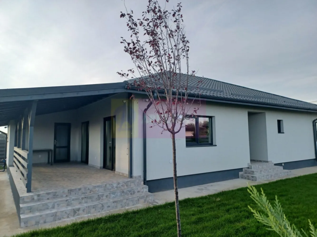 Casă 4 camere 162 mp, 115 utili, curte 505 mp, Săbăreni - Imobilul se află in localitatea Săbăreni, în apropierea celor 2 păduri, într-o zonă rezidențială nouă, ferită de traficul rutier, la aproximativ 170 m de strada Principală, DJ 602. Este o casă tip parter, cu structura de rezistență din beton armat și zidărie din căramidă, tencuită atât pe interior cât si pe exterior, peste care s-a aplicat polistiren de 150 mm cu EPS 80 si tencuiala decorativă siliconată Kober. Casa este acoperită cu țiglă metalică mată, ferestrele sunt Salamander cu geamuri tripan. Casa are placă din beton armat peste parter, podul este înalt (2,20 m la coamă), izolat termic cu celuloză, cu fereastră tip Velux. Locuința beneficiază de încălzire în pardoseală, centrală termică pe gaze în condensație. Finisajele interioare pot fi alese de cumpărător, intr-un anumit buget convenit cu vânzatorul. Casa are living, bucătărie (18 mp), 3 dormitoare, 2 băi, dresing, hol, cameră tehnică, pivniță si terasă acoperită. Imaginile din prezentare sunt de la o casă vândută. Termen de finalizare, la cheie: 2 luni. Pret 155.000 EUR, cu TVA 21% inclus. Nu se plătește comision.