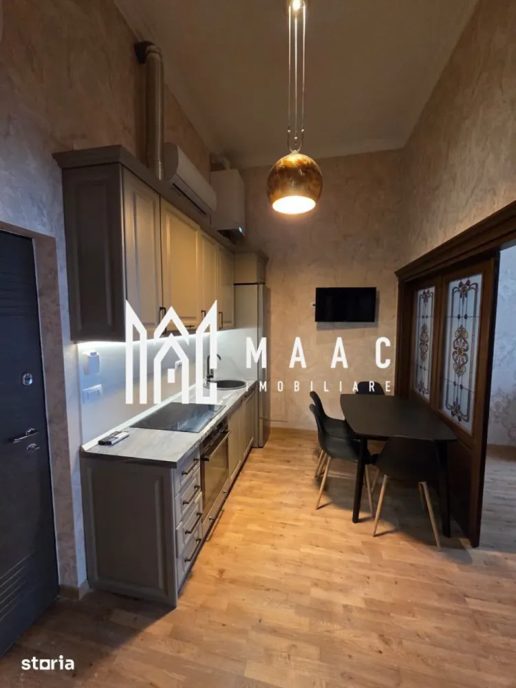 Apartament 2 camere | 55 MPU | Centrul Istoric - MAAC Imobiliare vă propune spre vânzare un apartament cu 2 camere situat în Centrul Istoric al Sibiului, în zona Orașul de Jos, una dintre cele mai apreciate și autentice zone ale orașului. Proprietatea beneficiază de o locație excelentă, ideală pentru persoanele care își doresc confort, eleganță și acces rapid către principalele puncte de interes din Sibiu.

Apartamentul a fost complet renovat în anul 2025 și mobilat premium, fiind pregătit pentru un stil de viață modern și confortabil. Înălțimea camerelor de aproximativ 3,80 m oferă un plus de spațiu, luminozitate și eleganță, iar materialele și dotările atent alese creează un ambient exclusivist și primitor.

Locuința are o suprafață utilă de 55 mp și beneficiază de o compartimentare practică și funcțională:
-living
-dormitor
-bucătărie complet mobilată și utilată
-baie
-hol
-pivniță inclusă

Printre dotările și avantajele proprietății se regăsesc:
-imobil complet renovat și mobilat premium
-izolație fonică și termică superioară
-încălzire în pardoseală Uponor cu control individual pe fiecare cameră
-centrală termică Viessmann Vitodens cu control WiFi
-aer condiționat Gree cu control WiFi
-dressing generos
-finisaje moderne și materiale premium
-camere înalte de aproximativ 3,80 m

Un avantaj aparte al acestei proprietăți îl reprezintă posibilitatea transformării bucătăriei într-un spațiu open-space cu livingul, prin intermediul unei uși triple din lemn de stejar cu vitralii, pliabilă la perete, oferind flexibilitate și un design interior elegant.

Apartamentul este situat în Centrul Istoric al Sibiului – Orașul de Jos, aproape de numeroase puncte de interes:
-muzee
-teatre
-restaurante și cafenele
-magazine și centre comerciale
-mall
-gară și autogară
-mijloace de transport în comun
-școli și grădinițe
-spații verzi pentru relaxare și plimbări

Datorită poziționării premium, renovării complete și dotărilor moderne, această proprietate reprezintă o alegere ideală atât pentru locuit, cât și pentru investiție în regim hotelier sau închiriere pe termen lung în centrul istoric al Sibiului.

Pentru mai multe detalii sau pentru programarea unei vizionări, vă rugăm să ne contactați și să specificați CP3089613.