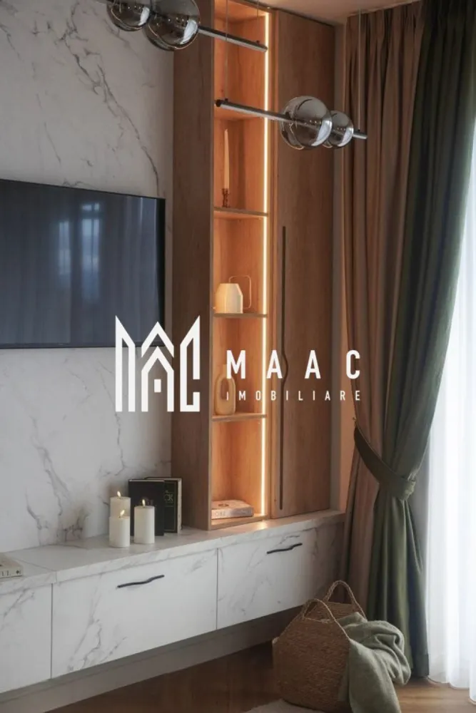 Apartament Premium | 3 camere | Balcon | Garaj subteran | Turnișor - MAAC vă propune spre închiriere un apartament premium cu 3 camere, conceput într-un stil minimalist și funcțional, unde confortul, eleganța și atenția la detalii se îmbină perfect pentru a oferi un spațiu ideal de locuit.

Apartamentul dispune de un living generos cu bucătărie open-space, amenajată modern și echipată cu hotă puternică cu evacuare exterioară, perfectă pentru un plus de confort și eficiență. Zona de zi este completată de o canapea extensibilă, ideală atât pentru relaxare, cât și pentru oaspeți.

Locuința beneficiază de două dormitoare luminoase, două băi finisate premium și mobilier realizat integral la comandă, inclusiv saltelele, pentru un nivel ridicat de confort și un design unitar, modern și rafinat.

Încălzirea se realizează prin pardoseală, cu centrală proprie și termostat individual în fiecare cameră, inclusiv în băi, oferind un control optim al temperaturii și eficiență energetică. Orientarea sud-estică asigură lumină naturală pe tot parcursul zilei.

Unul dintre punctele forte ale proprietății este balconul generos de 10 mp, care poate fi amenajat în funcție de nevoile și preferințele viitorului chiriaș. Proprietarii sunt deschiși la sugestii pentru a transforma experiența locuirii într-una cât mai plăcută.

Apartamentul beneficiază și de loc de parcare în garajul subteran, iar accesul se face într-un ansamblu rezidențial modern și liniștit, cu multă zonă verde, pomi fructiferi, loc de joacă pentru copii, zonă de fitness, spații de relaxare, zonă de grătar și fire pit.

În plus, proprietatea are ieșire către o curte interioară amenajată cu zonă de fructe și legume, flori, arbuști decorativi și spațiu de relaxare, unde se poate oferi acces, dacă se dorește.

Poziționarea este excelentă, într-o zonă liniștită, cu acces facil către magazine precum Profi și Trans Agape, stații de autobuz, zona industrială și aeroport, aflate la aproximativ 5 minute cu mașina, iar centrul orașului și Piața Mare se află la doar 15 minute distanță.

Un apartament ideal pentru cei care își doresc un stil de viață modern, confortabil și echilibrat, într-un cadru verde și liniștit.

Pentru mai multe detalii și vizionări, vă rugăm să menționați ID : CP3081929
