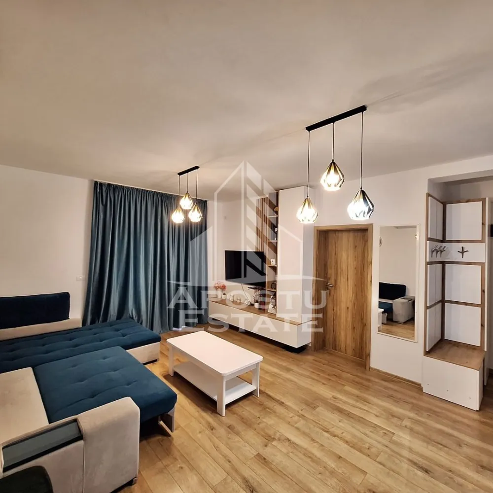 Apartament cu 2 camere mobilat cu gradina proprie de 50 mp in Giroc. - APOSTU ESTATE va propune spre vanzare un apartament cu 2 camere situat in Giroc la asfalt.
Drumul de acces spre imobil este asfaltat. In apropiere sunt magazine si supermarket-uri precum Lidl, Profi, Mega Image, Penny, Scoala, gradinita și parc la o distanta de 3-5 minute, acces facil la mijloace de transport in comun.

Apartamentul se vinde complet mobilat si utilat, precum se observa in imagini.

Imobilul are o suprafata de 56 mp utili, este situat la parter si dispune de 2 terase de pe care se face accesul in gradina.

Compartimentare:
- hol acces.
- bucatarie inchisa.
- dormitor.
- living.
- baie cu geam si cada.
- 2 terase.
- gradina proprie de 50 mp. 

Detalii tehnice:
- constructie realizata in anul 2023 din caramida Porotherm de 25 cm.
- exterior izolat cu polistiren de 10 cm eps 80.
- pereti despartitori complet din caramida (fara rigips) tencuiti mecanizat finisati cu glet si vopsea lavabila.
- geamuri termopan cu 3 sticle pentru izolare fonica si termica superioara, foarte mari si luminoase dotate cu rulori.
- centrala proprie pe gaz, sistem eficient de incalzire prin pardoseala.
- aparataje modulare Gewis.
- usa acces securizata, usi interioare Porta Doors.
- electrocasnice noi, in stare perfecta de functionare. (frigider, masina de spalat rufe, masina de spalat vase, aragaz, cuptor, hota)
- mobilier de calitate inalta, realizat pe comanda pe toata suprafata apartamentului.
- 1 loc de parcare in cf.
Utilitati complete: curent, apa de la retea, canalizare, gaz.

Pentru mai multe detalii nu ezitati sa ne contactati!

Acceptam orice fel de credit bancar. Oferim consultanta si solutii financiare prin colaboratorii nostri pentru a obtine cel mai avantajos credit Ipotecar sau Noua Casa.

Va asteptam cu drag la o vizionare chiar astazi!
CP2782745