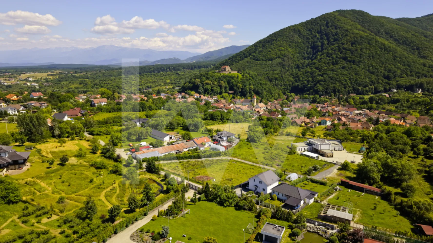 Teren 1340 mp în Cisnădioara – Cu Vedere la Cetatea Medievală și Munții Făgăraș - Imaginează-ți cum te trezești în fiecare dimineață cu Munții Făgăraș la orizont și cu o cetate medievală de peste 800 de ani veghind dealul din fața ta. Acest teren de 1340 mp, situat în Cisnădioara — una dintre cele mai pitorești și autentice localități din Mărginimea Sibiului — îți oferă exact această priveliște, în fiecare zi.
De pe parcelă se vede direct Cetatea Cisnădioarei, una dintre cele mai vechi și mai bine conservate biserici fortificate din Transilvania, ridicată în stil romanic la finalul secolului al XII-lea. Pe lângă valoarea istorică, dealul cetății oferă o panoramă spectaculoasă spre Munții Cibinului și culmile Făgărașului — exact priveliștea de care te vei bucura și tu, direct din curtea casei tale.
Caracteristicile terenului:
Cu o formă dreptunghiulară și acces printr-o stradă privată, terenul este intravilan, cu destinație pentru construcția unei case, vile sau pensiuni — liniște și intimitate garantate, fără vecini gălăgioși sau trafic. Beneficiezi deja de apă curentă direct pe parcelă, un avantaj important pentru orice proiect de construcție. Infrastructura este pregătită pentru dezvoltare: există deja o conductă de canalizare de 65 mm pe teren, fiind necesară doar montarea unei mini-stații de pompare pentru racordarea completă. Gazul și curentul electric sunt prezente în apropiere, cu posibilitate de extindere — îți poți planifica racordările exact după nevoile proiectului tău.
De ce Cisnădioara?
Pentru cei din București care își doresc o evadare reală din agitația capitalei, Cisnădioara este alegerea perfectă: un sat sătesc cu sute de ani de istorie, la doar 10 km de Sibiu și 17 km de Aeroportul Internațional Sibiu (zboruri directe din București). Te bucuri de liniștea muntelui, de trasee de drumeție și ciclism la doar câteva sute de metri de poartă, dar ai la îndemână tot ce oferă un oraș cultural important — restaurante, magazine, evenimente, școli.
Fie că vrei o casă de vacanță în care să te retragi din weekend în weekend, o reședință permanentă într-un decor de poveste, sau o investiție inteligentă într-o zonă cu potențial turistic în continuă creștere, acest teren are toate ingredientele unei povești de viață frumoase.
Preț: 139.900 euro, negociabil.
Locurile cu o astfel de poveste și priveliște nu apar des pe piață. Programează o vizionare și descoperă personal frumusețea acestui loc.
 


