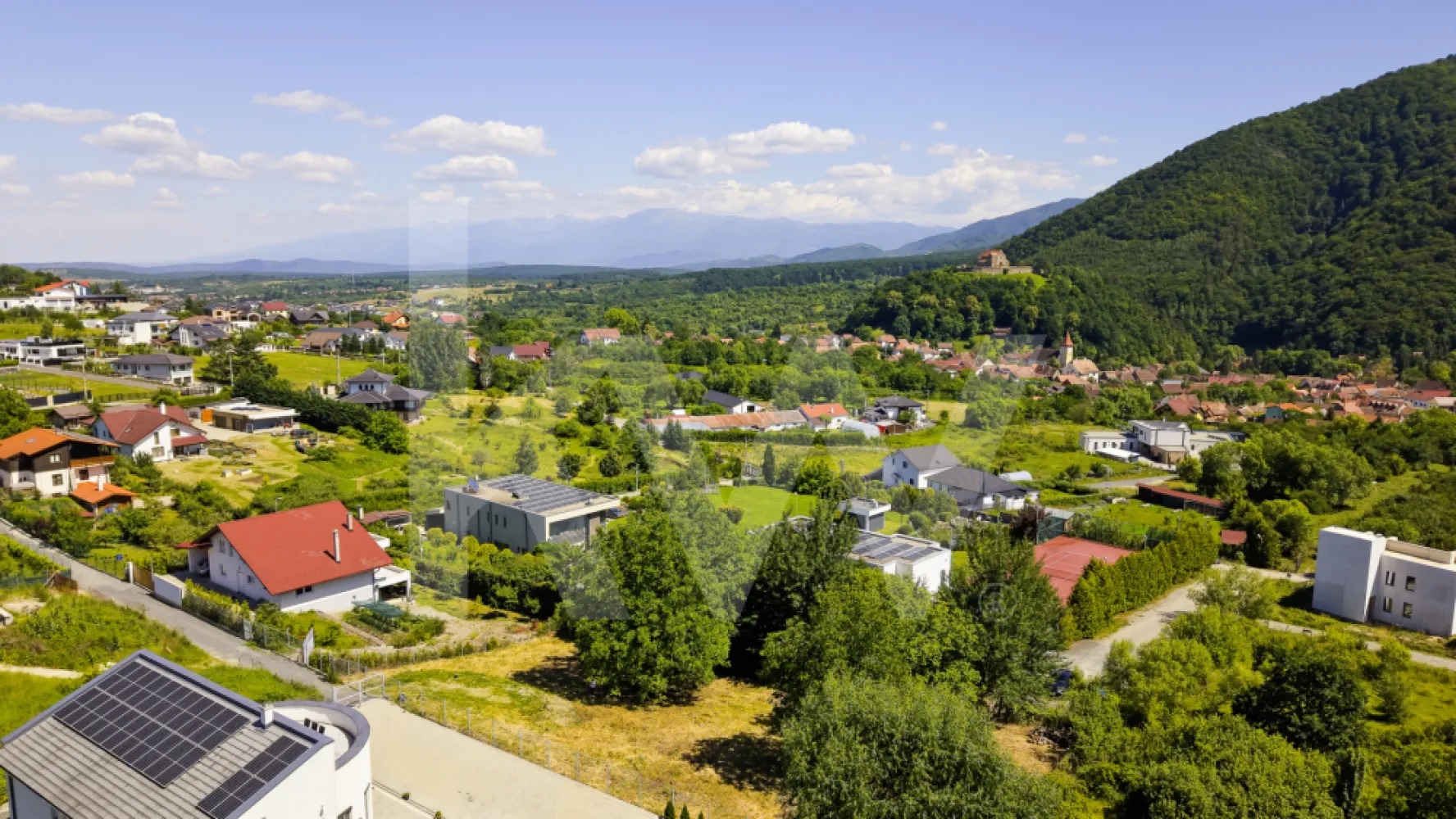 Teren 1340 mp în Cisnădioara – Cu Vedere la Cetatea Medievală și Munții Făgăraș - Imaginează-ți cum te trezești în fiecare dimineață cu Munții Făgăraș la orizont și cu o cetate medievală de peste 800 de ani veghind dealul din fața ta. Acest teren de 1340 mp, situat în Cisnădioara — una dintre cele mai pitorești și autentice localități din Mărginimea Sibiului — îți oferă exact această priveliște, în fiecare zi.
De pe parcelă se vede direct Cetatea Cisnădioarei, una dintre cele mai vechi și mai bine conservate biserici fortificate din Transilvania, ridicată în stil romanic la finalul secolului al XII-lea. Pe lângă valoarea istorică, dealul cetății oferă o panoramă spectaculoasă spre Munții Cibinului și culmile Făgărașului — exact priveliștea de care te vei bucura și tu, direct din curtea casei tale.
Caracteristicile terenului:
Cu o formă dreptunghiulară și acces printr-o stradă privată, terenul este intravilan, cu destinație pentru construcția unei case, vile sau pensiuni — liniște și intimitate garantate, fără vecini gălăgioși sau trafic. Beneficiezi deja de apă curentă direct pe parcelă, un avantaj important pentru orice proiect de construcție. Infrastructura este pregătită pentru dezvoltare: există deja o conductă de canalizare de 65 mm pe teren, fiind necesară doar montarea unei mini-stații de pompare pentru racordarea completă. Gazul și curentul electric sunt prezente în apropiere, cu posibilitate de extindere — îți poți planifica racordările exact după nevoile proiectului tău.
De ce Cisnădioara?
Pentru cei din București care își doresc o evadare reală din agitația capitalei, Cisnădioara este alegerea perfectă: un sat sătesc cu sute de ani de istorie, la doar 10 km de Sibiu și 17 km de Aeroportul Internațional Sibiu (zboruri directe din București). Te bucuri de liniștea muntelui, de trasee de drumeție și ciclism la doar câteva sute de metri de poartă, dar ai la îndemână tot ce oferă un oraș cultural important — restaurante, magazine, evenimente, școli.
Fie că vrei o casă de vacanță în care să te retragi din weekend în weekend, o reședință permanentă într-un decor de poveste, sau o investiție inteligentă într-o zonă cu potențial turistic în continuă creștere, acest teren are toate ingredientele unei povești de viață frumoase.
Preț: 139.900 euro, negociabil.
Locurile cu o astfel de poveste și priveliște nu apar des pe piață. Programează o vizionare și descoperă personal frumusețea acestui loc.
 

