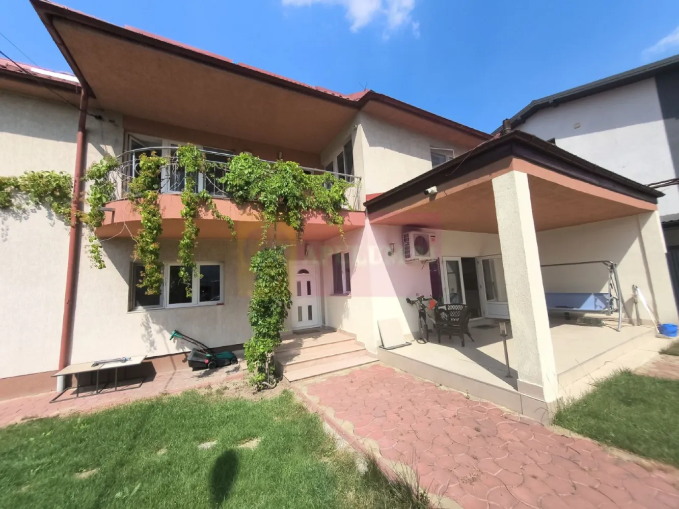 Vila de lângă Catedrala Ortodoxă ,,Sfânta Cuvioasă Parascheva" - Vindem vila de peste drum de Catedrala Ortodoxă Sfânta Cuvioasă Parascheva, cu acces din strada Sfântul Ioan Iacob Hozevitul, strada alăturată Catedralei. Casa se află într-o zonă centrală și extrem de frumoasă din Voluntari, aici ne bucurăm de multe facilități și avem acces la toate utilitățile. Imobilul cuprinde un corp principal de casă dispus pe două nivele plus mansardă, un corp secundar dispus doar pe parter care are însă placă de beton și permite extindere, o anexă acoperită pentru activități diverse și o curte splendidă foarte frumos amenajată. Corpul principal dispus pe parter și etaj oferă posibilitatea de a amenaja după bunul plac o mansardă spațioasă care beneficiază de trei ferestre tip Velux, bine izolată dar nefinisată, între etaj și terasă având placă de beton. Frontul stradal este generos și pe partea dinspre Catedrală avem pomi fructiferi tineri și tufe de trandafiri. Configurația corpului principal este foarte plăcută și extrem de practică, accesul se face fie pe intrarea principală fie direct prin bucătăria imensă și bine luminată. La parter afară de bucătăria tip salon care beneficiază și de o zonă de tip lounge, 2 (două) dormitoare mari și luminoase cu orientare sudică, o baie spațioasă și bine echipată ce beneficiază de fereastră pentru aer proaspăt, un dressing încăpător care deasemenea beneficiază de fereastră și are mai multe zone de depozitare evident plus o cameră tehnică și o cameră pentru menajeră sau pentru oaspeți care stau mai mult timp ce beneficiază de baie proprie cu cabină de duș. La etaj avem alte 4 (patru) dormitoare, o baie mare, o zonă de loisir cu bibliotecă în proximitatea scării de marmură și o cameră pentru depozitare, toate dormitoarele de la etaj au acces la balcoane tip terasă, dormitoarele mai apropiate de scara de marmură au orientare sudică și au acces spre balconul care oferă o priveliște superbă spre Catedrala Sfânta Cuvioasă Parascheva iar cele două dormitoare aflate în capătul holului au acces facil la baia bine echipată de la etaj și beneficiază de un balcon deschis tip terasă de aproximativ 20mp ce oferă o priveliște splendidă spre propria curte. Curtea este foarte ușor de întreținut, avem aspersoare și o diferențiere frumoasă a diferitelor zone. În proximitatea corpului principal de casă avem gazon și jnepenișuri iar în apropiere de zona de parcare avem o minidumbravă cu 5 conifere mature, două magnolii deasemenea mature și un smochin bine aclimatizat plus alte plante. Parcarea este umbrită de o boltă de viță de vie aflată pe rod bineînțeles. Zona de parcare se închide într-un spațiu acoperit aflat în prelungirea corpului secundar, spațiu care beneficiază de curent electric și care poate fi folosit pentru activități de atelier sau ca garaj acoperit. Corpul secundar de casă este gândit ca o zonă de party cu o zonă de bar, un open-space de peste 50mp, două grupuri sanitare, o zonă tehnică și chiar și o bucătărie. O casă superbă pe care vă invit să o vizionați. Daniel Apulum94