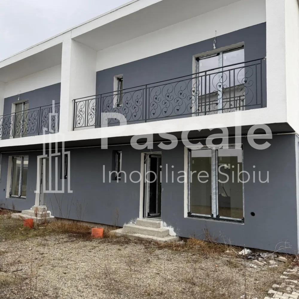 Duplex modern de vânzare – Tropinii Vechi, Rășinari | Natură, liniște și confort - Vă propunem spre vânzare un duplex elegant, situat într-o zonă exclusivistă și liniștită din Tropinii Vechi – Rășinari, ideal pentru o familie care își dorește confort, intimitate și aer curat, la doar câteva minute de Sibiu.Suprafață utilă: 101 mpCurte proprie: 299 mpLocuri de parcare: 2Compartimentare practicăParterLiving generos cu geam panoramic și acces direct în curteBucătărie separatăHolBaie cu geam pentru aerisire naturalăSpațiu de depozitareEtaj3 dormitoare luminoaseBaie cu geamBalcon cu vedere relaxantăDotăriTâmplărie termopanCentrală termică proprieCablu TV și internet DigiCurent trifazicDrum de acces cu piatră cubicăZonă aerisită, cu vecini selectațiStadiu: la gri – ideal pentru a-ți personaliza casa exact după gustul tău.Această proprietate îmbină perfect avantajele vieții la casă cu proximitatea orașului, fiind o investiție excelentă atât pentru locuire, cât și pentru viitor.