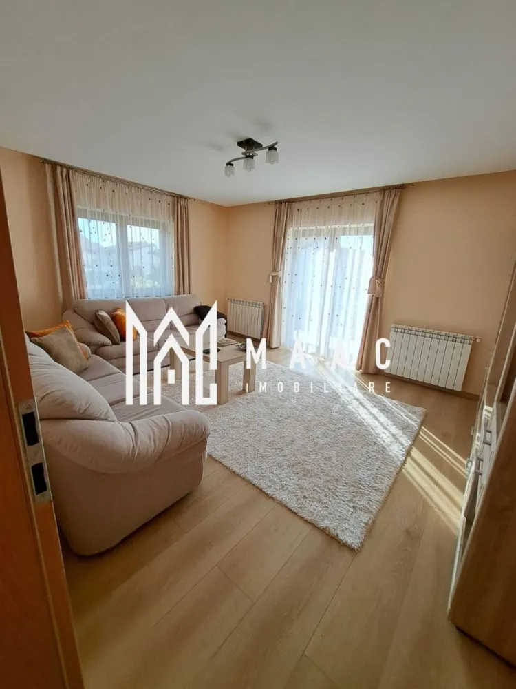 Casă individuală | 184 MPU | Teren 500MP | Șura Mare - MAAC Imobiliare vă propune spre vânzare o casă individuală modernă, cu 5 camere, situată în Șura Mare, la doar câteva minute de Sibiu, într-o zonă liniștită, ideală pentru familie.

Proprietatea dispune de o suprafață utilă de 184 mp și este amplasată pe un teren generos de 500 mp, oferind spațiu, confort și intimitate.

Compartimentare:
Demisol:
Garaj spațios
Cameră multifuncțională
Camera centralei
Pivniță
Baie de serviciu

Parter:
Living luminos
3 dormitoare
Bucătărie separată
Hol
Baie

Locuința beneficiază de sistem de încălzire pe gaz sau pe peleți, oferind flexibilitate și eficiență energetică.

Exteriorul este amenajat cu zonă verde, pomi fructiferi și curte pavată, ideală pentru relaxare sau petrecerea timpului în aer liber. Strada este în curs de asfaltare, cu termen estimat de finalizare în 2–3 luni, ceea ce va aduce un plus de confort și valoare proprietății.

Casa se vinde complet mobilată și utilată și poate fi predată imediat.

Pentru mai multe detalii sau pentru programarea unei vizionări, vă rugăm să ne contactați.
Specificați ID-ul CP2926583.