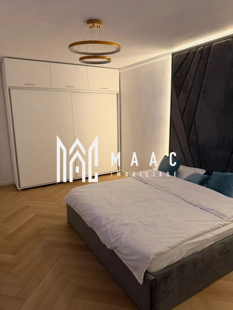 Apartament 3 camere decomandat | Sibiu Hipodrom 4 | 60 mp, parcare - Apartament cu 3 camere decomandat de închiriat în Sibiu, pe Strada Doamna Stanca, în zona Hipodrom 4, cu 60 mp utili, balcon și loc de parcare privat.

Detalii proprietate:
• Suprafață utilă: 60 mp, suprafață construită: 78 mp
• Compartimentare: living, 2 dormitoare, bucătărie separată, baie, hol cu spații de depozitare și balcon
• Etaj 1 din 5, imobil construit în 2020
• Stare interioară: ultrafinisat, confort lux
• Complet mobilat și utilat, pregătit pentru mutare imediată
• Încălzire în pardoseală, mobilier realizat la comandă și iluminat ambiental LED
• Parchet montat în model chevron și finisaje premium cu aspect de marmură
• Bucătărie complet echipată cu mașină de spălat vase, frigider, plită, cuptor și hotă
• Living amenajat cu televizor și zonă de relaxare
• 1 loc de parcare privat inclus

Localizarea pe Strada Doamna Stanca oferă acces rapid către Shopping City Sibiu, supermarketuri, restaurante, farmacii, școli, grădinițe, centre de fitness și mijloace de transport în comun. Zona este apreciată pentru infrastructura modernă și dezvoltarea rezidențială continuă.

Contactați echipa MAAC Imobiliare pentru o vizionare și menționați Cod anunț CP3197309.