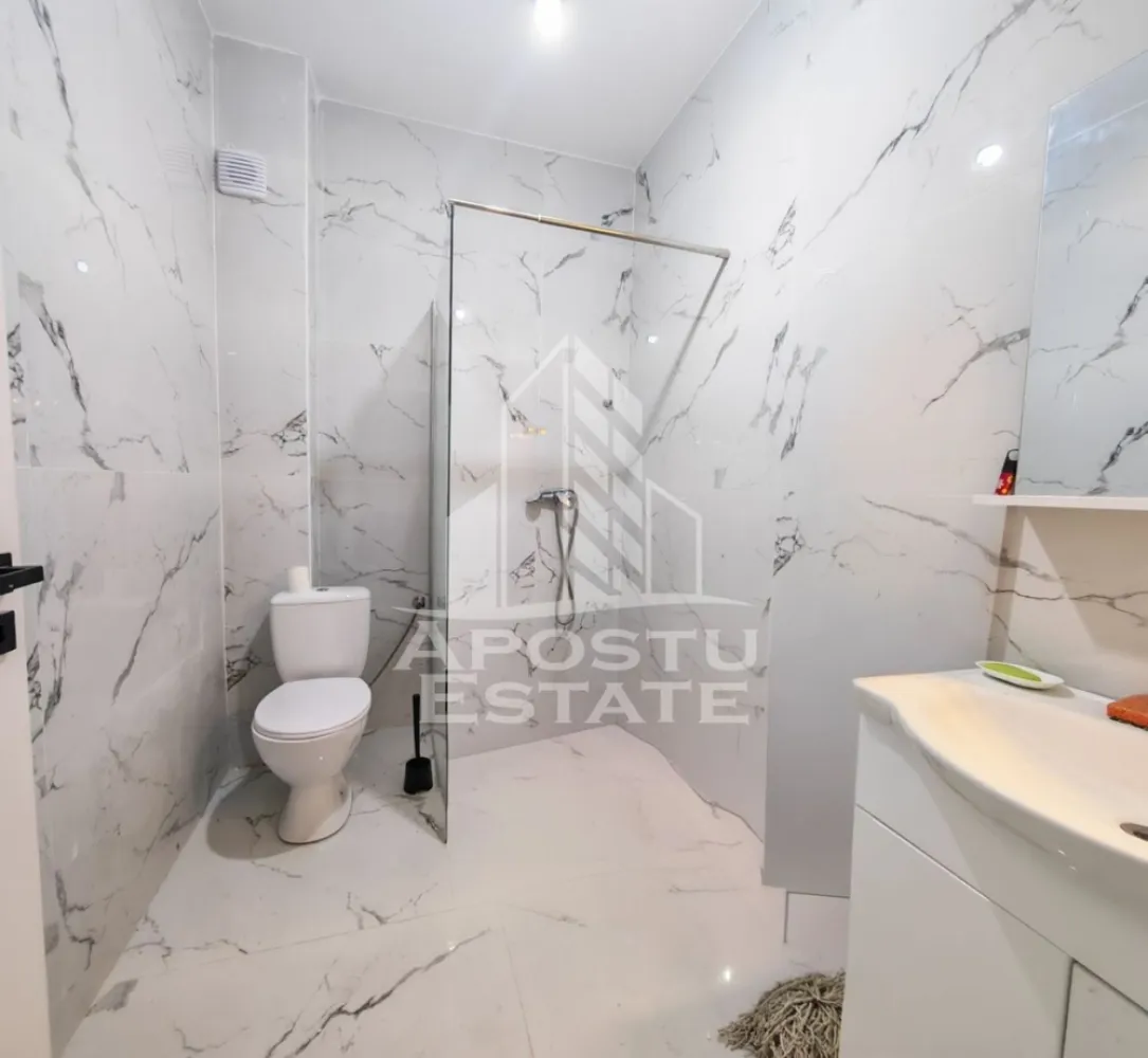 Apartament nou de vanzare cu 2 camere, parțial mobilat, Giroc - Apostu Estate va ofera spre vanzare un apartament nou, partial mobilat si utilat, cu 2 camere, decomandat complet. 
Bucatarie inchisa. 
Situat la etajul 3 al unui imobil nou, intabulat in anul 2025, in Timis, Giroc, zona Calea Urseni.
Aproximativ 1 km distanta fata de Zone Cafe 2 si Mega Image Calea Urseni Timisoara. Acces facil la centura ocolitoare a orasului. Doar 300 m fata de prima statie a mijloacelor de transport in comun.

Imobil realizat din caramida Porotherm de 30 cm pe exterior, 25 cm zidurile pe interior si 11.5 zidurile de compartimentare la bai.
Izolatie de 10 cm EPS 80.
Acoperis din tigla.

Loc de parcare propriu inscris in cartea funciara.
Patru apartamente pe etaj. 
Regim de inaltime: P + 2 + M. 
Acoperis din tigla. 
Tamplarie PVC, geamuri tripan.

Confortul termic se realizeaza cu ajutorul centralei proprii pe gaz, incalzire in pardoseala.

Apartamentul dispune de 53 mpu, plus un balcon de aproximativ 5 - 6 mp. 
Compartimentat astfel:
- hol de acces generos
- bucatarie inchisa, 8 mp
- living, 18.5 mp
- dormitor, 14 mp
- baie cu dus, rigola si toaleta suspendata cu rezervor incorporat, 5 mp
- balcon deschis 

Agentia imobiliara Apostu Estate va ofera consultanta bancara gratuita prin intermediul colaboratorilor nostri pentru alegerea celui mai potrivit tip de credit, astfel incat tu sa devi noul proprietar al acestui apartament.

Va asteptam cu drag la o vizionare!