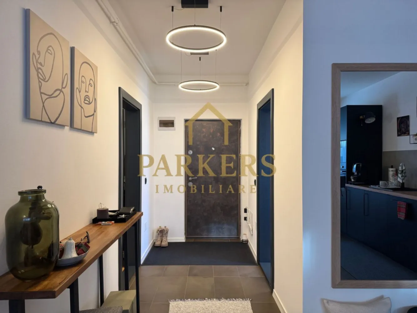 Apartament Modern cu Design Contemporan in Grigorescu Cluj-Napoca - Parkers Imobiliare vă prezintă spre vânzare o proprietate exclusivistă, situată într-una dintre cele mai apreciate zone ale cartierului Grigorescu, pe strada Donath. Acest apartament nu este doar o locuință, ci un concept de lifestyle modern, unde funcționalitatea întâlnește estetica minimalistă.
​- Configurație și Compartimentare
​Cu o suprafață utilă de 55,85 mp excelent optimizată, proprietatea impresionează prin fluiditatea spațiului și luminozitatea naturală.
​Zona de zi: Living spațios, inundat de lumină, integrat perfect cu o bucătărie open-space cu design industrial-chic.
​Zona de odihnă: Dormitor retras, configurat pentru a asigura un confort acustic și vizual maxim.
​Terasa (13,09 mp): Un spațiu exterior generos, care extinde zona locuibilă și oferă un loc privat pentru relaxare.
​Baie modernă: Finisaje premium în tonuri naturale, cu dotări sanitare de ultimă generație.
​- Dotări și Finisaje High-End
​Proprietatea se vinde complet mobilată și utilată, fiind gata pentru mutare imediată. Printre punctele forte menționăm:
​Bucătărie complet echipată: Electrocasnice încorporate gama Bosch, mobilier negru mat și blat cu textură de lemn.
​Sistem de iluminat: Corpuri circulare LED cu design minimalist și iluminat ambiental integrat.
​Confort termic: Centrală termică Bosch, radiatoare verticale de design și tâmplărie de înaltă calitate.
​Materiale: Parchet de calitate superioară, placări ceramice în tonuri neutre și piese de mobilier realizate la comandă.
​- Localizare de Top
​Situat in Grigorescu, imobilul beneficiază de avantajele unei zone rezidențiale liniștite, dar cu acces facil către punctele de interes ale orașului:
​Proximitate față de zonele verzi și malul Someșului.
​Imobil nou, cu o cotă de teren de 56 mp inclusă în proprietate.
​Acces securizat și vecinătăți selecte.
​Parkers Imobiliare – Consultanță de încredere pentru investiții inteligente.