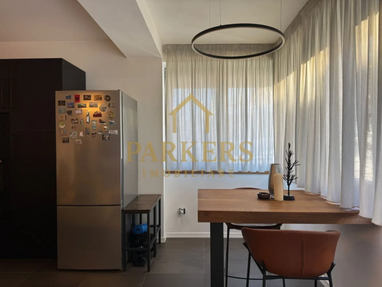 Apartament Modern cu Design Contemporan in Grigorescu Cluj-Napoca - Parkers Imobiliare vă prezintă spre vânzare o proprietate exclusivistă, situată într-una dintre cele mai apreciate zone ale cartierului Grigorescu, pe strada Donath. Acest apartament nu este doar o locuință, ci un concept de lifestyle modern, unde funcționalitatea întâlnește estetica minimalistă.
​- Configurație și Compartimentare
​Cu o suprafață utilă de 55,85 mp excelent optimizată, proprietatea impresionează prin fluiditatea spațiului și luminozitatea naturală.
​Zona de zi: Living spațios, inundat de lumină, integrat perfect cu o bucătărie open-space cu design industrial-chic.
​Zona de odihnă: Dormitor retras, configurat pentru a asigura un confort acustic și vizual maxim.
​Terasa (13,09 mp): Un spațiu exterior generos, care extinde zona locuibilă și oferă un loc privat pentru relaxare.
​Baie modernă: Finisaje premium în tonuri naturale, cu dotări sanitare de ultimă generație.
​- Dotări și Finisaje High-End
​Proprietatea se vinde complet mobilată și utilată, fiind gata pentru mutare imediată. Printre punctele forte menționăm:
​Bucătărie complet echipată: Electrocasnice încorporate gama Bosch, mobilier negru mat și blat cu textură de lemn.
​Sistem de iluminat: Corpuri circulare LED cu design minimalist și iluminat ambiental integrat.
​Confort termic: Centrală termică Bosch, radiatoare verticale de design și tâmplărie de înaltă calitate.
​Materiale: Parchet de calitate superioară, placări ceramice în tonuri neutre și piese de mobilier realizate la comandă.
​- Localizare de Top
​Situat in Grigorescu, imobilul beneficiază de avantajele unei zone rezidențiale liniștite, dar cu acces facil către punctele de interes ale orașului:
​Proximitate față de zonele verzi și malul Someșului.
​Imobil nou, cu o cotă de teren de 56 mp inclusă în proprietate.
​Acces securizat și vecinătăți selecte.
​Parkers Imobiliare – Consultanță de încredere pentru investiții inteligente.
