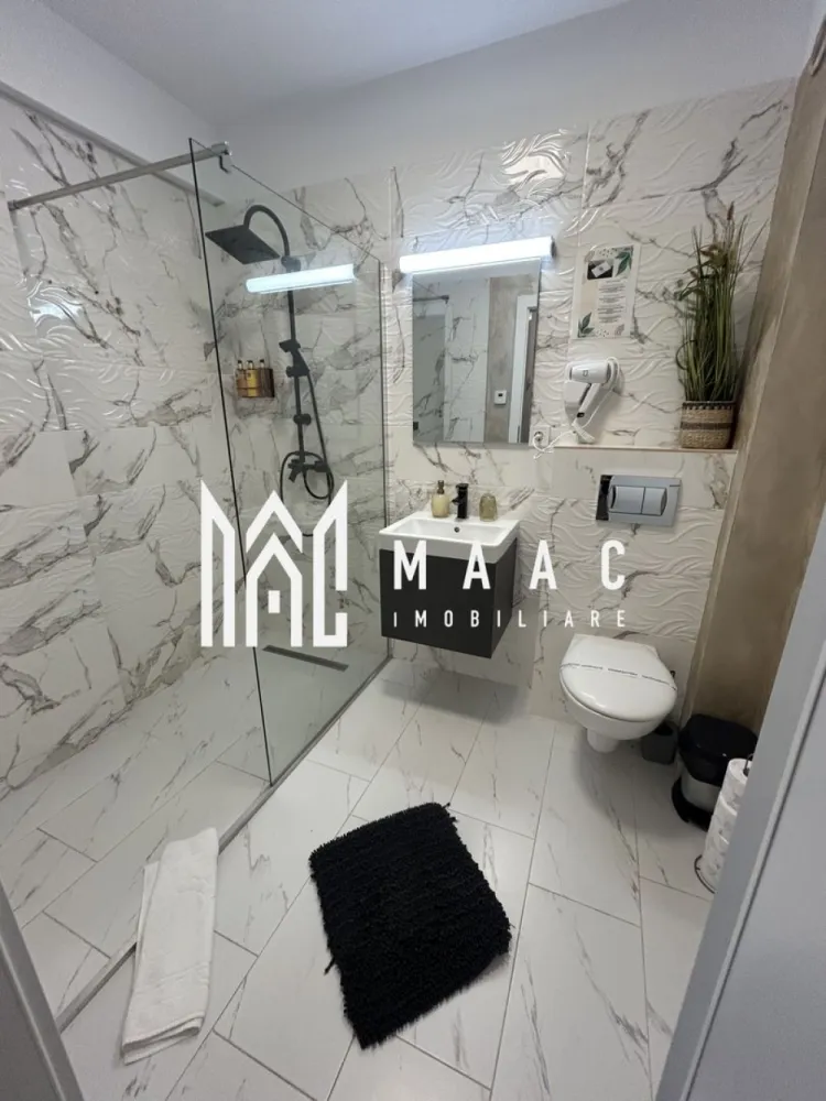 Apartament 3 camere | 71,8 mp utili | 2 terase | Etaj 1 | Parcare | LUX - MAAC Imobiliare vă propune spre vânzare un apartament modern cu 3 camere, amenajat la standarde premium, ideal atât pentru investiție în regim hotelier, cât și pentru închiriere pe termen lung sau locuință personală.

Imobilul este amplasat într-un bloc construit în anul 2021, prevăzut cu lift modern și o casă a scării elegantă și bine întreținută, oferind un mediu plăcut și un nivel ridicat de confort.

Apartamentul dispune de o suprafață utilă de 71,8 mp, completată de două terase generoase, fiind compartimentat eficient după cum urmează:
• 2 dormitoare matrimoniale
• living open-space cu bucătărie (cu posibilitate de delimitare)
• 2 băi spațioase
• 2 terase ample, ideale pentru relaxare

Locuința se vinde complet mobilată și utilată, într-un stil modern, fiind gândită pentru a oferi confort maxim și funcționalitate, cu numeroase spații de depozitare.

Dotări și avantaje:
• încălzire în pardoseală
• centrală termică proprie
• aer condiționat
• bucătărie complet echipată (plită electrică, frigider și electrocasnice)
• televizoare în fiecare cameră
• mobilier modern, de calitate superioară
• loc de parcare inclus

Apartamentul se prezintă în stare impecabilă, fiecare detaliu fiind atent ales pentru a crea un spațiu elegant, confortabil și funcțional.

Proprietatea reprezintă o oportunitate excelentă de investiție, fiind potrivită atât pentru exploatare în regim hotelier, cât și pentru închiriere pe termen lung sau locuință personală.

Bonus: Primele apartamente achiziționate beneficiază de spațiu de depozitare la subsol, ideal pentru obiecte personale sau sezoniere.

Această proprietate se adresează persoanelor care apreciază calitatea, confortul și un stil de viață modern și rafinat.

Pentru mai multe informații sau pentru programarea unei vizionări, vă rugăm să ne contactați și să specificați ID: CP2955540