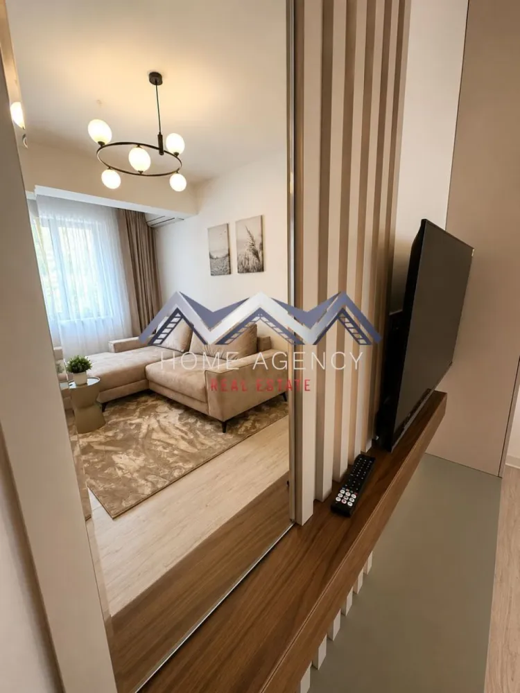 Apartament 2 camere | parcare subterană | Otopeni central - Vă propunem spre închiriere un apartament cu 2 camere, aflat la prima închiriere, care îmbină designul contemporan, finisajele atent alese și confortul unei locuințe amenajate cu grijă pentru viitorii săi locatari. Situat într-o zonă centrală din Otopeni, apartamentul oferă acces rapid către DN1 și principalele puncte de interes din Otopeni și Nordul Bucureștiului, fiind alegerea ideală pentru cei care își doresc un stil de viață modern, într-o locație excelent conectată.

Încă de la intrare, apartamentul se remarcă prin atmosfera luminoasă și aerisită, mobilierul realizat pe comandă și paleta cromatică neutră, care pune în valoare fiecare spațiu. Compartimentarea este eficientă și bine gândită, oferind un echilibru firesc între funcționalitate și confort.

Zona de zi reunește livingul și diningul într-un ambient primitor, ideal atât pentru momentele de relaxare, cât și pentru întâlnirile cu familia sau prietenii. Bucătăria, complet mobilată și utilată cu electrocasnice încorporate, completează armonios zona de zi și oferă tot confortul necesar utilizării de zi cu zi.

Dormitorul a fost amenajat într-un stil minimalist și elegant, oferind un ambient liniștit și relaxant, în timp ce baia completează locuința prin finisajele moderne și atenția acordată fiecărui detaliu.

Locuința beneficiază de încălzire în pardoseală, centrală termică proprie, aer condiționat, mobilier realizat pe comandă și dotări atent alese, de la electrocasnicele încorporate și mașina de spălat vase din bucătărie, până la mașina de spălat rufe cu funcție de uscător, amplasată în baie.

Vă invităm cu drag la o vizionare pentru a descoperi toate avantajele acestui apartament.