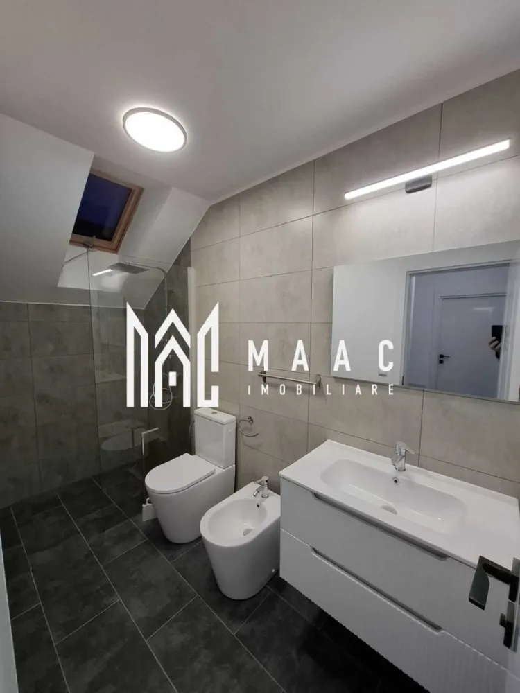 Casă 4 Camere | Prima Închiriere | Cisnădie - MAAC Imobiliare vă propune spre închiriere o casă, construită în anul 2025, situată în Cisnădie, într-o zonă bine poziționată, cu acces rapid către Sibiu, autostradă și principalele centre comerciale din zonă. Compartimentare • living / sufragerie spațioasă • 3 dormitoare • bucătărie separată • cameră tehnică • 3 băi • pod pentru depozitare Casa dispune de curte pavată de aproximativ 100 mp, oferind spațiu pentru relaxare sau parcare. Dotări și avantaje • încălzire în pardoseală atât la parter, cât și la mansardă • centrală termică pe gaz • băi complet mobilate • bucătărie complet mobilată și utilată • acces rapid către magazinele mari din Cisnădie și Sibiu • legătură rapidă cu autostrada Proprietatea oferă confort modern și eficiență energetică, fiind pregătită pentru mutare imediată. Pentru mai multe detalii sau pentru programarea unei vizionări, vă rugăm să ne contactați și să menționați ID-ul proprietății: CP2966831.