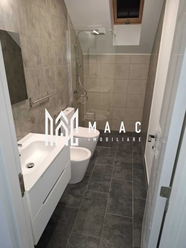 Casă 4 Camere | Prima Închiriere | Cisnădie - MAAC Imobiliare vă propune spre închiriere o casă, construită în anul 2025, situată în Cisnădie, într-o zonă bine poziționată, cu acces rapid către Sibiu, autostradă și principalele centre comerciale din zonă. Compartimentare • living / sufragerie spațioasă • 3 dormitoare • bucătărie separată • cameră tehnică • 3 băi • pod pentru depozitare Casa dispune de curte pavată de aproximativ 100 mp, oferind spațiu pentru relaxare sau parcare. Dotări și avantaje • încălzire în pardoseală atât la parter, cât și la mansardă • centrală termică pe gaz • băi complet mobilate • bucătărie complet mobilată și utilată • acces rapid către magazinele mari din Cisnădie și Sibiu • legătură rapidă cu autostrada Proprietatea oferă confort modern și eficiență energetică, fiind pregătită pentru mutare imediată. Pentru mai multe detalii sau pentru programarea unei vizionări, vă rugăm să ne contactați și să menționați ID-ul proprietății: CP2966831.