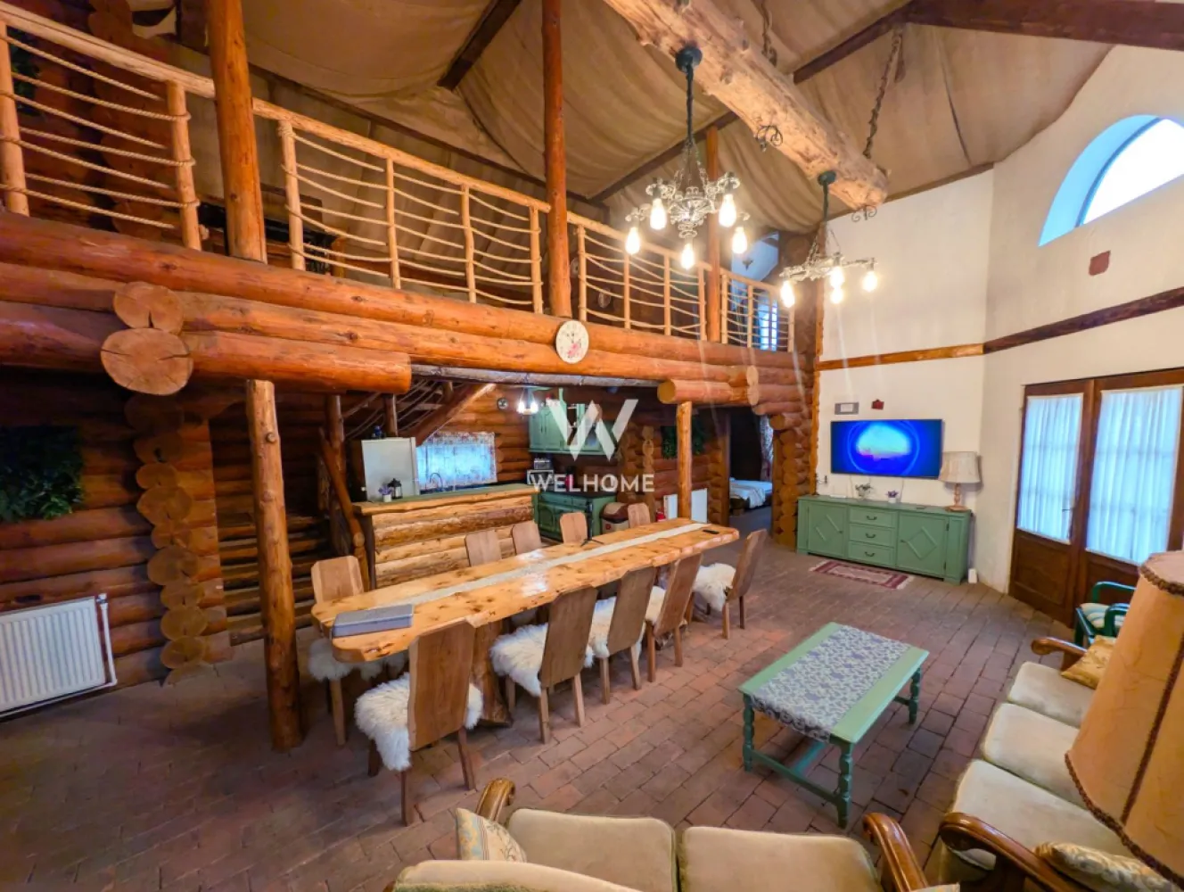 Cabana / Casa de vacanta pe Transfagarasan - Sibiu - Cabana "Rustic Balea"
Această proprietate este o casă de vacanță tip cabană construită predominant din lemn masiv rotund, oferind un refugiu montan ideal pentru grupuri mari. Cabana are o capacitate optimă de cazare de opt persoane, fiind dotată cu patru dormitoare matrimoniale. Un avantaj major pentru confortul oaspeților este faptul că fiecare dormitor beneficiază de baie proprie, modern utilată cu cabină de duș.

Spațiul de zi este extrem de generos, incluzând un living spațios cu tavan înalt, unde domină bârnele de lemn. Aici se găsesc o zonă de relaxare cu canapele amplasată lângă un șemineu tradițional din cărămidă și o masă lungă, din lemn masiv, pentru servit masa. Bucătăria interioară este complet utilată, integrată armonios în living, remarcându-se prin mobilierul vopsit în verde salvie.

În ceea ce privește materialele, cabana utilizează bârne groase, rotunde, din lemn masiv pentru structura principală și pereții interiori, conferind o estetică autentică de log cabin și o izolare excelentă. Pardoseala combină plăcut dușumeaua de lemn din dormitoare cu cărămida sau piatra arsă din living.

Pentru relaxare, cabana oferă facilități de wellness de lux: pe terasa exterioară, cu vedere directă la râu, se află un ciubăr (hot tub) din lemn. Lângă ciubăr, o saună privată interioară completează zona SPA. În exterior, există un foișor acoperit cu masă și bănci rustice, dotat cu o zonă de grătar din cărămidă.

Cadrul natural este de vis, proprietatea fiind situată pe malul unui râu de munte, la poalele muntilor Fagaras. Datorită poziționării sale strategice, cabana servește ca punct de bază ideal pentru explorarea zonei Transfăgărășanului (DN7C).

Cabana/casa de vacanta este listata pe site-urile cu profil turistic fiind foarte cautata si apreciata.

Pret: 299.000 euro.
Comision cumparator 2% + TVA.