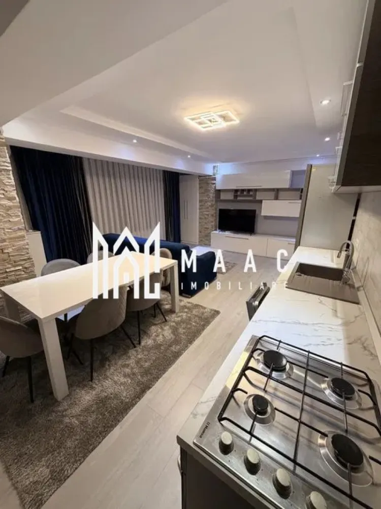 Apartament 2 camere | Șelimbăr – Doamna Stanca | Lângă Kaufland - MAAC Imobiliare vă propune spre închiriere un apartament modern cu 2 camere, situat în Șelimbăr, pe strada Doamna Stanca, într-un complex rezidențial apreciat, aflat în imediata apropiere a Kaufland Șelimbăr și la doar câteva minute de Shopping City Sibiu.

Locuința are o suprafață utilă de 58 mp (exclus balcon) și este compartimentată eficient, oferind un spațiu bine organizat:

living open space cu bucătărie complet echipată
dormitor spațios
baie modernă, dotată cu duș walk-in

Apartamentul este complet mobilat și utilat cu mobilier modern și electrocasnice de calitate, fiind pregătit pentru mutare imediată. Printre dotări se numără:

mașină de spălat rufe cu uscător (LG 2 în 1)
mașină de spălat vase
frigider, aragaz și cuptor
aer condiționat
televizoare în fiecare cameră
finisaje premium (parchet, gresie, faianță tip mozaic)

Imobilul dispune de locuri de parcare în regim „primul venit – primul servit”, însă locul de parcare nu este inclus în prețul chiriei.

Condiții de închiriere:
nu se acceptă animale de companie
disponibilitate imediata.

Pentru mai multe detalii și programarea unei vizionări, vă invităm să ne contactați, menționând ID-ul ofertei:CP2978046