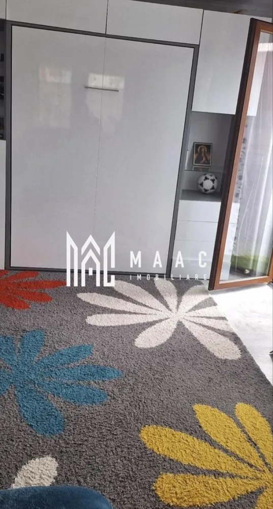 Apartament | 2 Camere | 56 Mp | Balcon | Șelimbăr - MAAC Imobiliare vă propune spre vânzare un apartament modern și primitor, situat chiar la intrarea în Șelimbăr, într-o zonă accesibilă și în plină dezvoltare, cu acces rapid către Sibiu și principalele puncte de interes.

Suprafață utilă: 56 mp
Balcon: 7 mp

Apartamentul este complet mobilat, oferind un ambient plăcut și fiind pregătit pentru mutare imediată, fără investiții suplimentare.

Compartimentare eficientă:

1 dormitor confortabil
Living spațios și luminos
Bucătărie separată
Baie modernă
Balcon generos de 7 mp, ideal pentru relaxare

Locuința se remarcă prin compartimentarea practică, lumina naturală din abundență și atmosfera caldă, fiind potrivită atât pentru locuit, cât și ca investiție sigură.

Datorită poziționării excelente, proprietatea beneficiază de acces rapid către Sibiu, centre comerciale, mijloace de transport și alte facilități importante.

Dacă îți dorești un cămin bine poziționat, cu spații bine gândite și confort sporit, acest apartament poate fi alegerea ideală.

Pentru mai multe detalii sau pentru programarea unei vizionări, vă rugăm să ne contactați specificând ID:CP2985167
