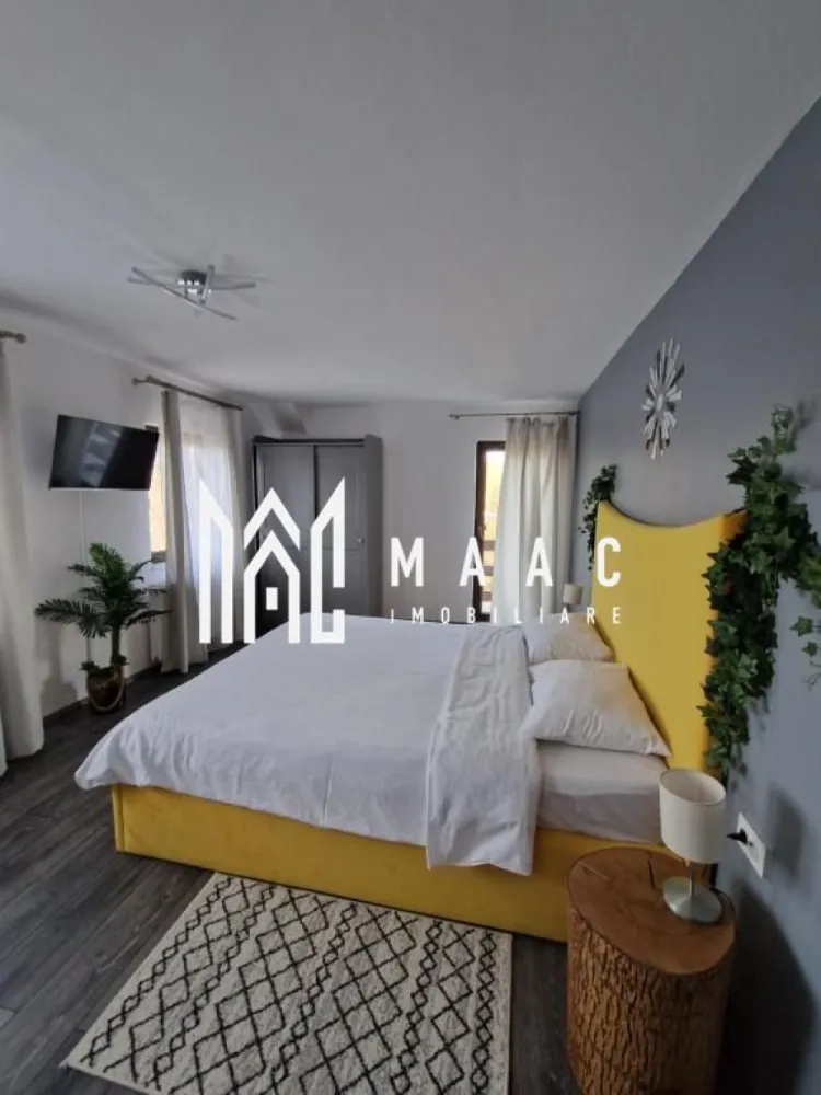 Pensiune Turistică | 360MPU | Curte | Oportunitate Investiție | Porumbacu de Sus - MAAC Imobiliare vă propune spre vânzare o pensiune / casă de vacanță complet funcțională, situată în Porumbacu de Sus, una dintre cele mai apreciate zone turistice din județul Sibiu, o proprietate cu activitate solidă de peste 4 ani și flux constant de turiști, pregătită pentru preluare imediată.

Construită în anul 2021 și menținută impecabil, proprietatea oferă o suprafață utilă de 360 mp, fiind organizată eficient pentru desfășurarea activităților turistice:

-clădire principală dispusă pe parter, etaj și pod mansardat
-5 unități de cazare, fiecare cu baie proprie și balcon
-un apartament, o cameră triplă și trei camere duble

Spațiile sunt luminoase, bine întreținute și adaptate cerințelor actuale din turism:
-living generos

-bucătărie complet utilată

-6 dormitoare

-6 băi

-terasă de aproximativ 20 mp

În exterior, proprietatea oferă facilități apreciate de turiști:
-bucătărie de vară
-foișor
-zonă de barbecue

Dotări tehnice și utilități:
-încălzire centrală pe peleți
-izolație exterioară de 10 cm
-acoperiș Bilka
-alimentare cu apă din rețea și fântână proprie
-contor trifazic

Proprietatea este amplasată pe un teren de 1.000 mp, dintre care aproximativ 900 mp reprezintă curte liberă, oferind posibilitatea extinderii cu facilități suplimentare precum saună, ciubăr sau noi spații de cazare.

În partea din spate a terenului se află o cabană secundară din lemn, de aproximativ 50 mp, dispusă P+M, locuibilă, ce necesită renovare și oferă potențial pentru extinderea capacității sau proiecte independente.

Curtea dispune de:
-6–7 locuri de parcare
-acces facil
-cadru natural liniștit

Poziționarea este un avantaj major, datorită proximității față de obiective turistice importante și trasee montane, ceea ce asigură vizibilitate și cerere constantă pe tot parcursul anului.

Proprietatea este ideală pentru investitori în turism, familii care doresc o afacere funcțională sau pentru dezvoltarea unui mini-complex turistic.

Pentru mai multe detalii și vizionarea acestei proprietăți /oportunități de investiție ,contactați-ne și specificați codul de identificare al proprietății ID: CP2819284