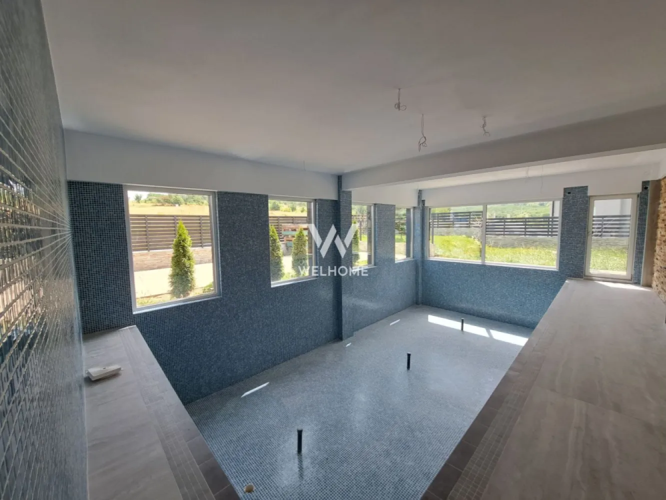 Vilă modernă premium cu piscină interioară, teren 1200 mp și panoramă - Descoperă o proprietate cu adevărat specială, concepută pentru cei care își doresc confort, intimitate și un stil de viață premium, într-o zonă liniștită, cu panoramă superbă asupra dealurilor din Cisnădie si spre Cisnadioara, la doar 15 minute de centrul Sibiului.
Această casă individuală, cu design modern ofera spații generoase și un flow perfect între interior și exterior, ideal pentru viața de familie sau chiar pentru un concept exclusivist de business (boutique retreat / centru wellness).

Proprietatea dispune de 240 mp utili și este amplasată pe un teren generos de 1200 mp, care oferă intimitate, spațiu verde și multiple posibilități de amenajare.
Un element rar întâlnit este piscina interioară de aproximativ 50 mp, un adevărat lux personal, care transformă locuința într-un spațiu de relaxare și wellness în orice sezon.
Zona de zi impresionează printr-un living amplu open-space cu bucătăria și zona de dining, gândite pentru conexiune și socializare, cu ieșire directă către terasa acoperită destinată zonei de barbeque.
Un alt avantaj major este garajul cu acces direct în holul casei, oferind confort și funcționalitate în viața de zi cu zi.
Compartimentare:
Parter:
 • hol de acces
 • baie
 • garaj cu acces direct în casă
 • cameră tehnică / lavanderie
 • spațiu de depozitare
 • piscină interioară (aprox. 50 mp)
 • living generos cu dining și bucătărie open-space
 • terasă acoperită pentru barbeque
Etaj:
 • hol
 • 4 dormitoare luminoase
 • 2 băi (un dormitor cu baie proprie)
 • terasă circulabilă cu acces din 3 camere – ideală pentru jacuzzi sau zonă lounge
 • balcon cu priveliște frumoasă către dealuri
Terenul de 1200 mp este terasat și oferă:
 • spațiu generos pentru parcarea mai multor mașini
 • zone pentru relaxare și petrecerea timpului cu familia și prietenii
 • vegetație tânără și posibilitatea de amenajare personalizată după propriul stil de viață.
Această proprietate este alegerea perfectă pentru cei care își doresc liniște, natură, spațiu și confort modern, într-o casă spectaculoasă aproape de oraș.
PRET: 550 000 EUR + 21 % TVA