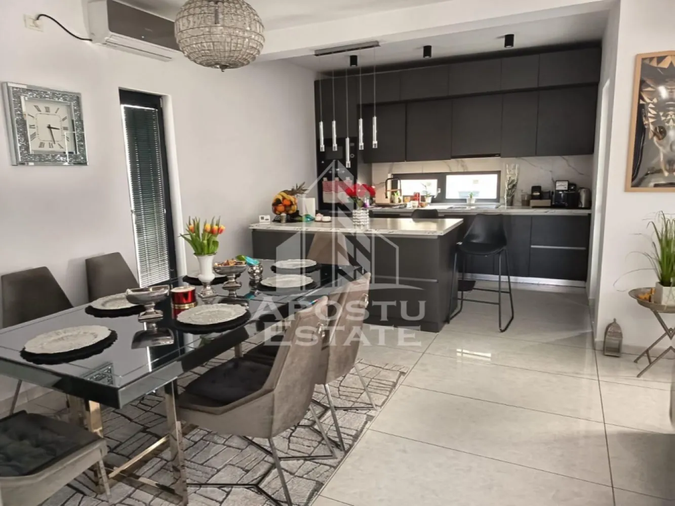 Duplex modern de vanzare in Dumbravita cinci camere - Apostu Estate va propune spre vanzare un duplex modern situat in Dumbravita, una dintre cele mai dinamice si cautate zone rezidentiale din proximitatea Timisoarei, ideala pentru familie sau investitie.

Imobilul are o suprafata utila de aproximativ 180 mp si este amplasat pe un teren de 330 mp, oferind un spatiu bine echilibrat intre interior si exterior.

Compartimentarea este practica si eficienta: 5 camere spatioase, 3 bai si 1 garaj, gandite pentru confortul unei familii moderne.

Constructia este finalizata in anul 2022, realizata din caramida, cu finisaje moderne si standarde actuale de locuire.

Dotari si beneficii:
 • Centrala proprie
 • Incalzire in pardoseala
 • Aer conditionat
 • Dressing
 • Bucatarie mobilata
 • Toate utilitatile: apa, gaz, curent, canalizare, internet, CATV
 • Strazi asfaltate si iluminat stradal

Avantaje zona:
 • Dumbravita – zona rezidentiala moderna, aerisita si in continua dezvoltare
 • Acces rapid catre Timisoara, zona de nord
 • Aproape de Padurea Verde – ideal pentru relaxare si activitati in aer liber
 • In proximitate: scoli, gradinite si centre educationale
 • Supermarketuri, magazine si farmacii in apropiere
 • Restaurante, cafenele si servicii diverse
 • Acces facil la mijloace de transport

Proprietatea se remarca prin locatie, constructie recenta si compartimentare eficienta, fiind o alegere potrivita atat pentru locuinta proprie, cat si pentru investitie.