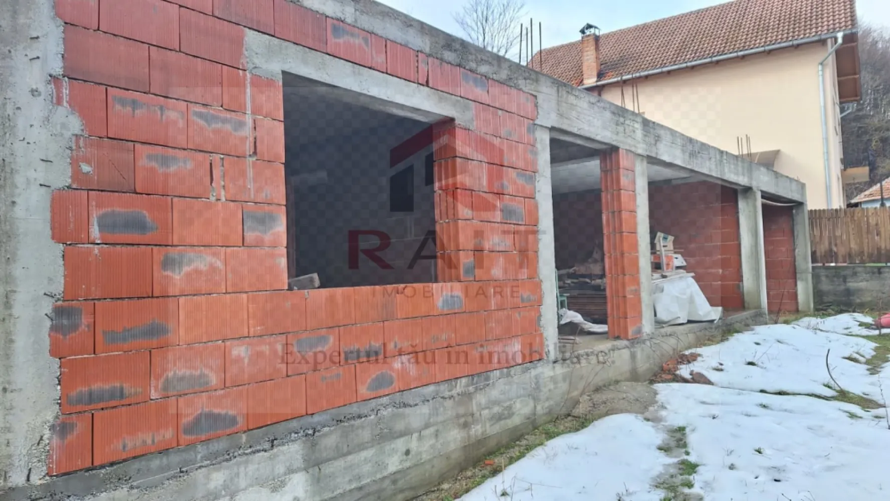Casa de vanzare Cicanesti Arges - ​Acest proiect rezidențial modern, aflat în faza incipientă de construcție, este conceput pentru a oferi un spațiu de locuit confortabil și funcțional, optimizat, pentru familiile care caută un echilibru între estetică și utilitate. Structura actuală, solidă și bine definită, reprezintă fundația unei locuințe ce va îmbina elemente arhitecturale, contemporane cu un stil clasic, adaptat nevoilor urbane sau semi-urbane.
​La parter, planul inițial include un living spațios, luminos, cu deschidere către zona de dining și bucătăria, creând un spațiu fluid, ideal pentru socializare și petrecerea timpului în familie. De asemenea, la acest nivel se va regăsi o baie de serviciu și, posibil, un birou sau un dormitor secundar, oferind flexibilitate în amenajare. Accentul se pune pe suprafețe vitrate mari, pentru a maximiza lumina naturală și a crea o conexiune armonioasă cu exteriorul.
​Elementul distinctiv al acestei construcții va fi etajul mansardat, care urmează să fie adăugat. Acesta va transforma casa într-o locuință cu adevărat versatilă, oferind spații private și intime. Mansarda va găzdui dormitoarele principale, posibil cu băi proprii și dressinguri, optimizând utilizarea fiecărui metru pătrat. Ferestrele de tip Velux sau lucarnele adăugate vor asigura o iluminare excelentă și o ventilație naturală, contribuind la crearea unei atmosfere aerisite și plăcute. Acoperișul va fi proiectat cu o pantă potrivită pentru a integra estetic mansarda, adăugând un farmec aparte siluetei casei.
​Exteriorul va fi finisat cu materiale de calitate superioară, combinând tencuiala decorativă în nuanțe neutre cu accente de lemn sau piatră, pentru un aspect cald și primitor. Un balcon discret sau o terasă mică la etaj ar putea completa designul, oferind un spațiu exterior suplimentar.
​Această casă în construcție promite să devină o reședință modernă și funcțională, perfect adaptată stilului de viață contemporan, oferind intimitate și confort, dar și spații ample pentru divertisment și relaxare.