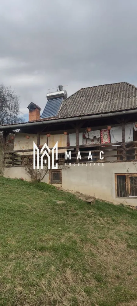 Casa Veche I 8000 mp I Abrud I Alba - MAAC Imobiliare va ofera spre vanzare la iesirea din orasul Abrud, unde munții își întind brațele către vale, se află Casa Vântului. Nu era o locuință obișnuită; era o poveste întruchipată în piatră și lemn, cu răsuflarea pământului în fiecare colț.

Casa locuita de proprietari in acest moment
Era compusă din două dormitoare, fiecare cu ferestre largi ce prindeau soarele dimineața și lună noaptea. Bucătăria, mică și eficientă, avea un cuptor cu lemne care pâlpâia în serile de iarnă, iar aroma de plăcinte umplea întreaga casă. Baia, simplă și curată, era locul liniștit unde apa curgea dintr-un izvor propriu. Camera, ascunsă după o ușă masivă, păstra conserve, jambale și mirodenii, păstrând proviziile pentru lungile ierni. Scările interioare, din lemn solid, duceau la holul luminat de o lampă veche, care era punctul de întâlnire al tuturor căilor din casă. Terasa, largă și acoperită, era ochiul casei spre lume, unde stăteau să privească cerul și livezile.

Grajdul și Fânarul
Departe de casă, dar încă în sânul proprietății, se afla grajdul. Nu era doar un loc pentru animale; era un spațiu de viață. Căluții își scuturau coamele la briza de amiază, și vacile rumega liniștit. Fânarul, înalt și umbrit, păstra iarba uscată, mirosul de summer înghețat în bălți de aur.

Livezile și Pământul
Livezile se întindea pe o parte a terenului de 8000 de metri pătrați – meri, peri și cireși își înălțau ramurile spre soare. În primăvară, ele se îmbrăcau în floare, iar toamna, rodul era atât de mult că se împărțea cu întreg satul. Restul pământului era o alternanță de pajiști și pădure mică, unde copacii bătrâni păstrau tăcerea veșnică a munților.

Viața în Casa Vântului
Aici, viața nu era măsurată în ore, ci în sezoane. Diminețile începeau cu cântecul cocoșilor, zilele erau umplute cu lucrul pământului și îngrijirea animalelor, și serile se încheiau pe terasa, sub stele. Casa nu era doar un loc de locuit; era un organism care trăia și respira cu cei care o umpleau. Fiecare cameră avea o poveste, fiecare colț păstra o amintire, și întreaga proprietate era o hartă a unei vieți simple, dar pline.

În Abrud, judetul Alba, Casa Vântului nu era doar o construcție; era o parte a pământului, o bucată de istorie și un refugiu pentru sufletele care căutau liniștea și rostul în ritmurile naturale ale vieții. Așa stătea, solidă și generoasă, așteptând să împartă din caldul ei cu oricine trecea pe la ușa ei.
Pentru mai multe detalii precizati telefonic ca ati vazut anuntul cu ID CP3047140.