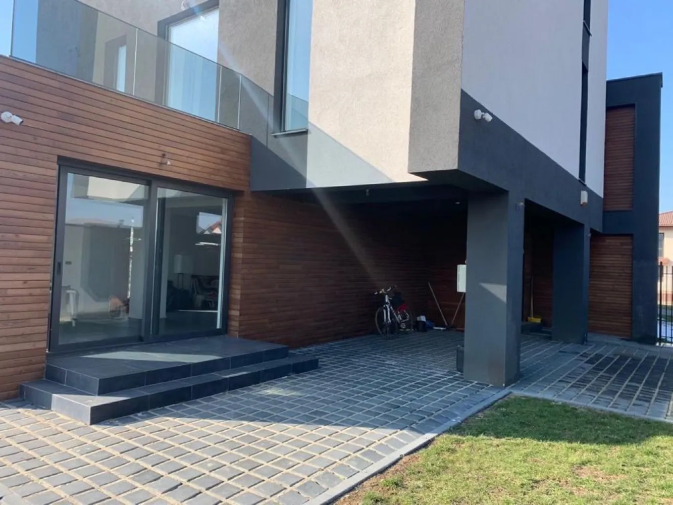 Vila 5 camere - BMS HOME CONCEPT - Strada Campul Pipera - Va prezentam spre vanzare o vila cu 5 camere ( birou, 3 dormitoare, living cu bucatarie si zona relaxare, 3 bai, 2 terase) situata in str Campul Pipera 39 Voluntari, in imediata vecinatate a Cartierului Henri Coanda, la o distanta de 3,7 km de Directia Regim permise de conducere si Inmatriculari auto.
Vila este finalizata in anul 2022, este formata din P + ETJ 1 + ETJ 2, are o suprafata utila totala de 276 mp, beneficiaza de 336 MP mp teren cu o deschidere de 15ml. Curtea libera este in suprafata de 260mp, prevazuta cu pavaj , 2 locuri de parcare, alei pietonale si gazon .
Suprafata utila totala este distribuita pe etaje dupa cum urmeaza :
PARTER :
Living + Bucatarie - 70,50 mp; Baie - 3,10 mp; Camera tehnica - 2,80 mp
 
ETAJUL 1
Dormitor+ Dressing - 34,40 mp, Baie - 15,40 mp ,Hol+Scara - 26,68 mp , Terasa - 27,40 mp
 
ETAJUL 2
Dormitor 1 - 14 mp; Dormitor 2 - 14 mp, Terasa - 4,50mp; Hol +Casa Scarii+Zona relaxare - 43,40mp; Baie - 10,30 mp.
Camerele sunt luminoase, elegante, inalte cu finisaje de lux . La baza semnarii contractului final de vanzare cumparare vor sta urmatoarele documente : act dobandire teren, autorizatie construire , documente de calitate , carte tehnica, certificat energetic, receptie la terminarea lucrarilor, cadastru+intabulare, etc. 
STRUCTURA IMOBILUI este realizata din cadre de beton armat cu inchideri de zidarie porotherm de 30 cm, iar compartimentarea interioara din BCA de 15 cm.
HIDROIZOLATIA este realizata atat pe terasele circulabile si necirculabile, cat si pe planseu in 5 straturi(EPS 200 DE 10CM - cu efect termoizolant)
TERMOIZOLATIA - fatada ventilata in partea inferioara a imobilului este realizata cu vata minerala de 10 cm si finisata cu lambriuri din lemn termotratat. Fatada neventilata din partea superioara este realizata cu vata minerala bazaltica de 10 cm si tencuieli decorative. Intradosul planseului este termoizolat cu vata de 10 cm.
TAMPLARIA EXTERIOARA s-a realizat din ferestre cu profile de aluminiu cu punte termica si placate la exterior cu sticla, feronerie GU, culoare sable noir, sticla 32 mm, 6 foi, 4 season- WEnegru-6 Float. Izolarea tamplariei a fost realizata cu membrane EPDM(membrane monostrat sintetic 100% care isi pastreaza proprietatile la -40 grade)
ATIC SI GLAF METIGLA vopsite in camp electrostatic de 0,5 cm grosime, culoare sable noir.
USILE DE INTERIOR sunt calitate premium tip FILOMURO cu balamale ascunse si broasca magnetica.
USA DE EXTERIOR este metalica din aluminiu dur cu rupere termica si vopsita in camp electrostatic in nuanta lemnului. Usa confera o rezistenta marita la conditiile climatice severe cat si la coroziune.
INSTALATIA SANITARA
- la exterior : scurgeri pluviale incastrate in termosistem cu sistem de drenaj cu 3 camine colectoare.
- la interior : sistem de incalzire in pardoseala tip PURMO care se alimenteaza prin agent termic (apa calda)furnizat cu ajutorul distribuitoarelor de incalzire PURMO. Exista grup de pompare PURMO, convectoare de caldura PURMO, hidrofor, statie de dedurizare si statie de filtrare a apei, centrala termica Viessman 33 kw cu boiler incorporat de 100 l, radiatoare port prosop pentru bai, electroventil de apa pentru sistem anti-inundatii.
FINISAJE BAI : Izolatie tip Sika. gresie si faianta antiderapanta de calitate superioara tip Marazzi, pereti si pardoseli din microciment. Baile sunt complet echipate cu obiecte sanitare su accesorii( lavoare, baterii, cabine dus si cazi freestanding din compozit), vas de toaleta suspendat si bideu cu rezervor incastrat tip TECE, blaturi din lemn masiv. Baile sunt echipate cu prize etanse cu contact de protectie si instalatie de iluminat preinstalata pentru corpurile de iluminat.
FINISAJE INTERIOARE : Lavabil interior de calitate superioara, aer conditionat cu traseu frigorific din cupru, izolatie fonica cu polistiren de 5 cm, trepte metalice suspendate finisate cu lemn termotratat, parchet tip dusumea, pardoseli microciment living, bucatarie, circuit electric pentru insula din bucatarie, traseu evacuare hota, termostat caldura pentru fiecare camera.
FINISAJE TERASA : glaf piatra 2 cm cu cant tip WASSERNAS, pardoseala DECK din lemn termotratat, balustrada aluminiu cu sticla 8.8.3 laminat, securizat, float plus gray, , priza exterioara.
INSTALATIE ELECTRICA(220V/380V- CURENT TRIFAZIC) : Intrerupatoare touch tip LIVOLO, preechipare statie exterioara incarcare auto, sistem iluminat ambiental exterior, prize exterioare, senzori anti - inundatie si anti- incendiu.Sistemul BMS implementat permite sa controlam si sa monitorizam functiile casei.
Zona permite acces rapid catre Parcul Herastrau cat si in toate celelalte puncte de interes ale Capitalei. Strazile de acces catre vila sunt largi, regimul de inaltime al zonei este de P+ 2, nu se creeaza puncte de aglomerare catre Bulevardul principal. Zona este ferita de zgomotul intens stradal cat si de formarea intensa a poluarii.