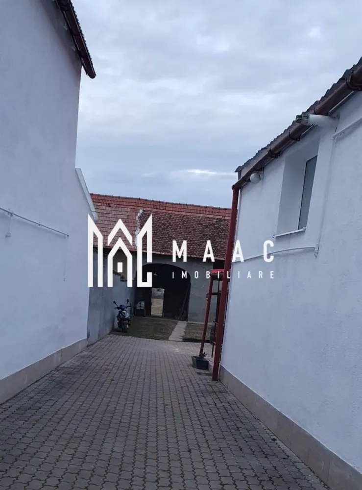 Casă Săsească Hosman | 3 camere | Teren 1076 mp - Vă prezentăm o casă fermecătoare, ideală pentru cei care caută liniștea și frumusețea vieții la țară, situată la doar 25 km de Sibiu. Această proprietate renovată recent oferă toate condițiile moderne, păstrând în același timp farmecul rustic. Caracteristici principale: Suprafață teren: 1076 mp, împărțită inteligent între curte, grădină și zone de utilitate. Compartimentare: 3 camere spațioase și luminoase. 1 bucătărie practică și bine dotată. 2 băi moderne, ideale pentru confortul familiei. Pivniță uscată, potrivită pentru depozitare. Dotări și facilități: Locuința a fost renovata recent, oferind un mediu confortabil și primitor. Apă, gaz, curent electric, fosa septica. Încălzire eficientă: Centrală termică, calorifere pe hol, sobe de teracota( necesita racordate la gaz). Anexe și exterior: Grajd și șură, cu multiple posibilități de utilizare. Garaj si spațiu in curte pentru mașini. Curte pavată, perfectă pentru relaxare și activități în aer liber. Grădină generoasa pentru cei care iubesc grădinăritul. Această proprietate este ideală pentru cei care doresc să se bucure de spațiu generos, natură și intimitate. 📞 Contactați MAAC Imobiliare pentru mai multe informații sau pentru a programa o vizionare, menționează CP2778739 !