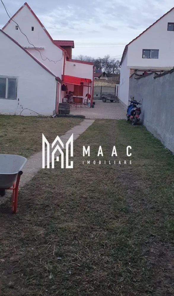 Casă Săsească Hosman | 3 camere | Teren 1076 mp - Vă prezentăm o casă fermecătoare, ideală pentru cei care caută liniștea și frumusețea vieții la țară, situată la doar 25 km de Sibiu. Această proprietate renovată recent oferă toate condițiile moderne, păstrând în același timp farmecul rustic. Caracteristici principale: Suprafață teren: 1076 mp, împărțită inteligent între curte, grădină și zone de utilitate. Compartimentare: 3 camere spațioase și luminoase. 1 bucătărie practică și bine dotată. 2 băi moderne, ideale pentru confortul familiei. Pivniță uscată, potrivită pentru depozitare. Dotări și facilități: Locuința a fost renovata recent, oferind un mediu confortabil și primitor. Apă, gaz, curent electric, fosa septica. Încălzire eficientă: Centrală termică, calorifere pe hol, sobe de teracota( necesita racordate la gaz). Anexe și exterior: Grajd și șură, cu multiple posibilități de utilizare. Garaj si spațiu in curte pentru mașini. Curte pavată, perfectă pentru relaxare și activități în aer liber. Grădină generoasa pentru cei care iubesc grădinăritul. Această proprietate este ideală pentru cei care doresc să se bucure de spațiu generos, natură și intimitate. 📞 Contactați MAAC Imobiliare pentru mai multe informații sau pentru a programa o vizionare, menționează CP2778739 !