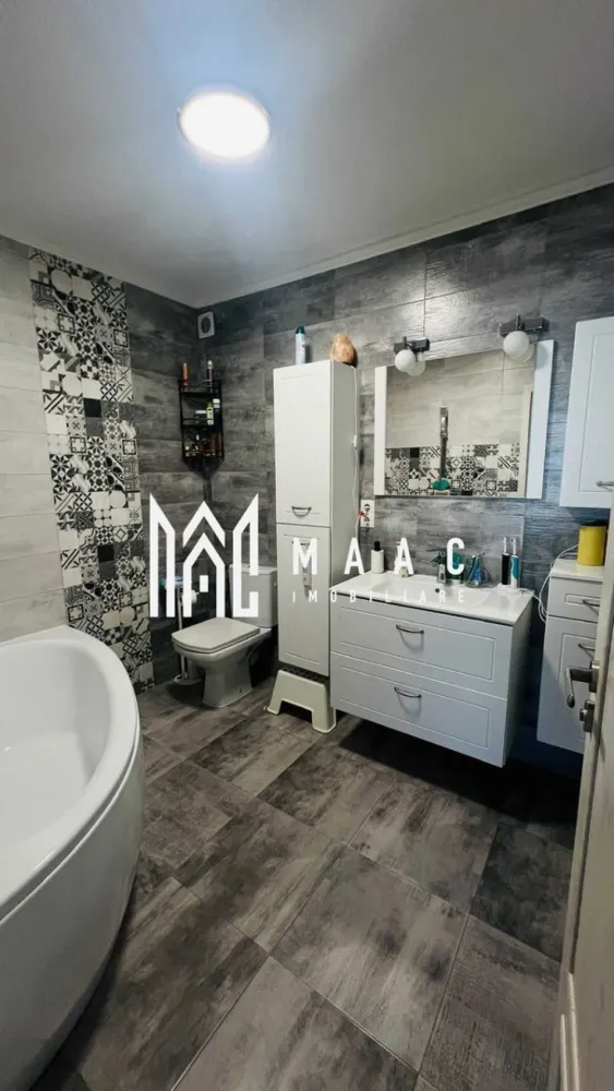 Casa 4 Camere | 160mpu | 2 Locuri Parcare | Selimbar - MAAC Imobiliare vă propune spre vânzare o casă situată în Șelimbăr, o locuință modernă, complet mobilată și utilată, potrivită pentru o familie care își dorește confort, spațiu generos și finisaje de calitate într-o zonă liniștită, cu acces facil către facilitățile orașului.

Proprietatea are o suprafață utilă de 160 mp și este organizată pe regim de înălțime P+1+M, beneficiind de orientare est–vest și de o curte totală de 120 mp, care include grădină în spate de aproximativ 60 mp, grădină frontală și două locuri de parcare.

Compartimentarea locuinței este realizată astfel:

Parter:
-living și zonă de dining spațioasă
-bucătărie open space
-baie de serviciu
-cameră tehnică
-multiple spații de depozitare

Etaj 1:
-dormitor matrimonial cu baie proprie și dressing
-al doilea dormitor cu dulap și zonă de depozitare
-birou sau dormitor mic
-baie principală

Mansardă:
-spațiu open space complet amenajat, cu soluții de depozitare

Locuința beneficiază de dotări moderne care asigură confort și eficiență:
-centrală termică Bosch cu termostat smart
-4 aparate de aer condiționat Daikin controlabile prin telecomandă și aplicație mobilă
-jaluzele exterioare electrice cu sistem smart
-ferestre termopan cu plase de insecte
-ferestre Velux cu folie solară
-mobilier personalizat FrontMob
-panouri electrice independente pentru fiecare nivel

Spațiul exterior este complet amenajat și include:
-zonă verde cu pomi fructiferi
-pergolă retractabilă cu lounge și zonă de dining
-grătar și spațiu utilitar
-zonă pentru joacă sau sport

Proprietatea se vinde complet mobilată și utilată, fiind pregătită pentru mutare.

Pentru mai multe detalii, vă rugăm să menționați telefonic că ați văzut anunțul cu CP2772104.